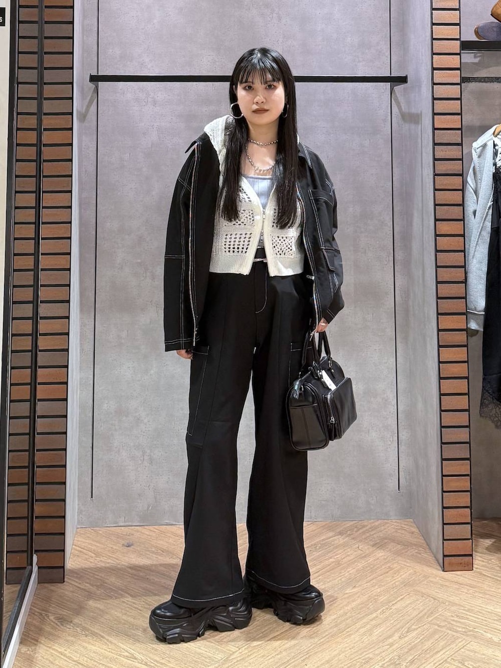 ブラック系のスニーカー、ブラック系のショルダーバッグ、ブルー系のタンクトップを着用したレディースの春コーディネートの2枚目の写真