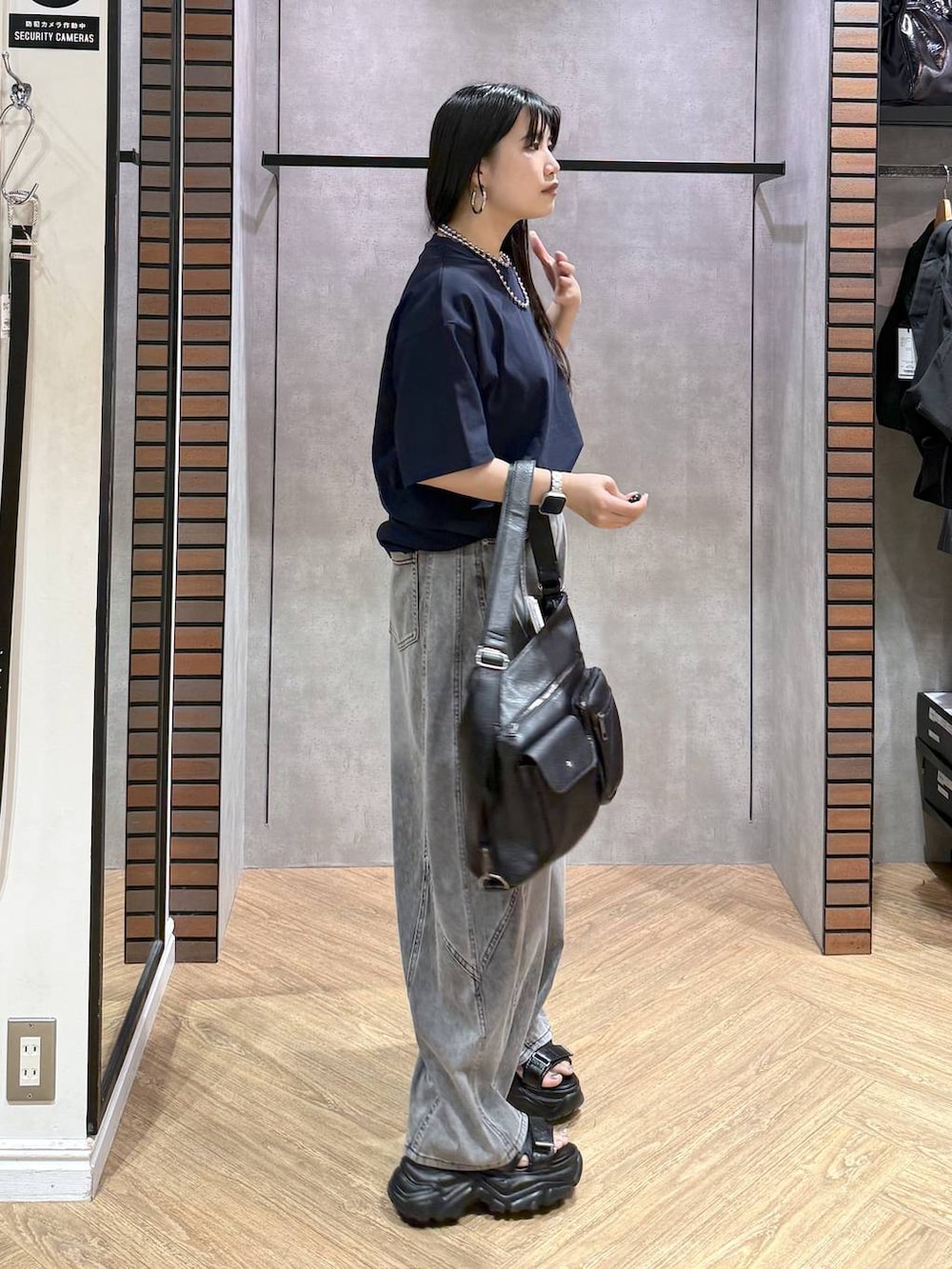 ブラック系のショルダーバッグ、ブラック系のデニムパンツ、ブラック系のサンダルを着用したレディースの夏コーディネートの4枚目の写真