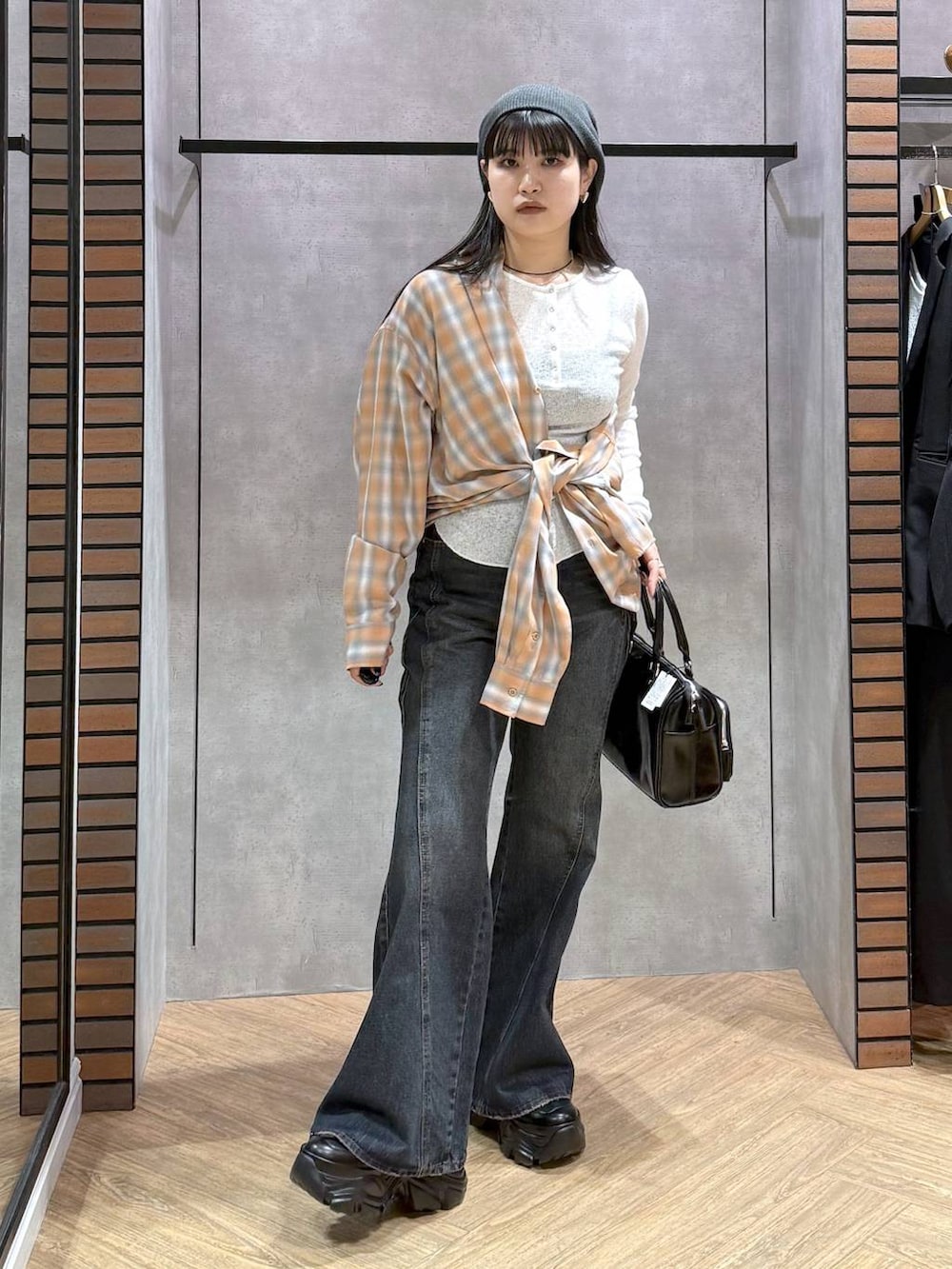 ブラック系のスニーカー、ブルー系のデニムパンツ、ブラック系のショルダーバッグを着用したレディースの春コーディネートの4枚目の写真