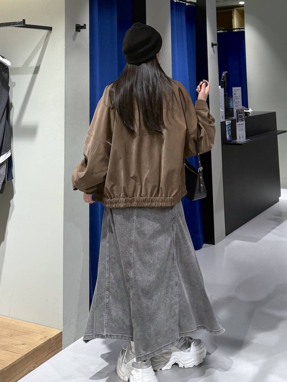 ホワイト系のスニーカー、ブラック系のハンドバッグ、ホワイト系のニット/セーターを着用したレディースの春コーディネートの3枚目の写真