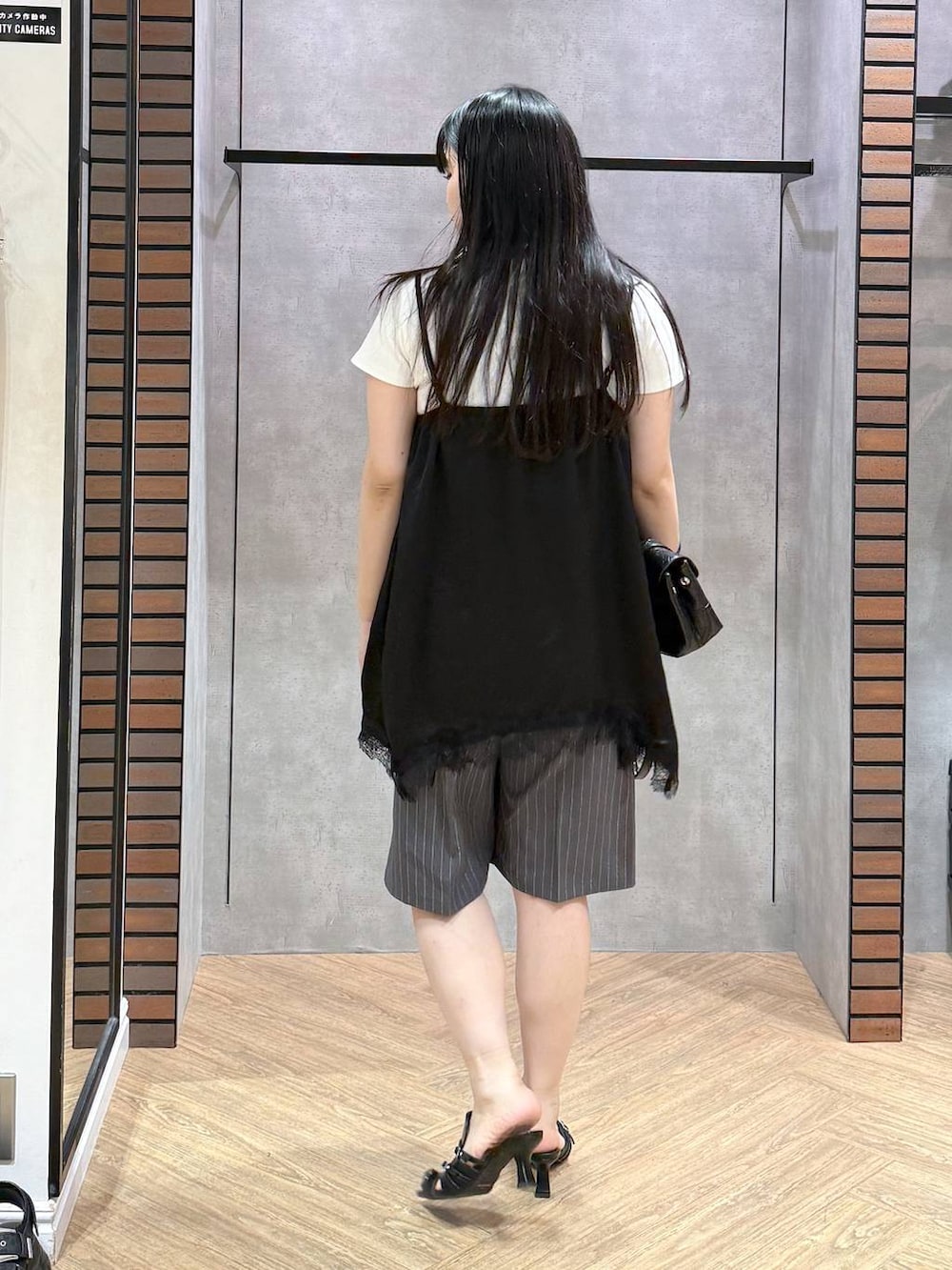 ブラック系のサンダル、ホワイト系のTシャツ/カットソー、ブラック系のキャミソールを着用したレディースの夏コーディネートの2枚目の写真