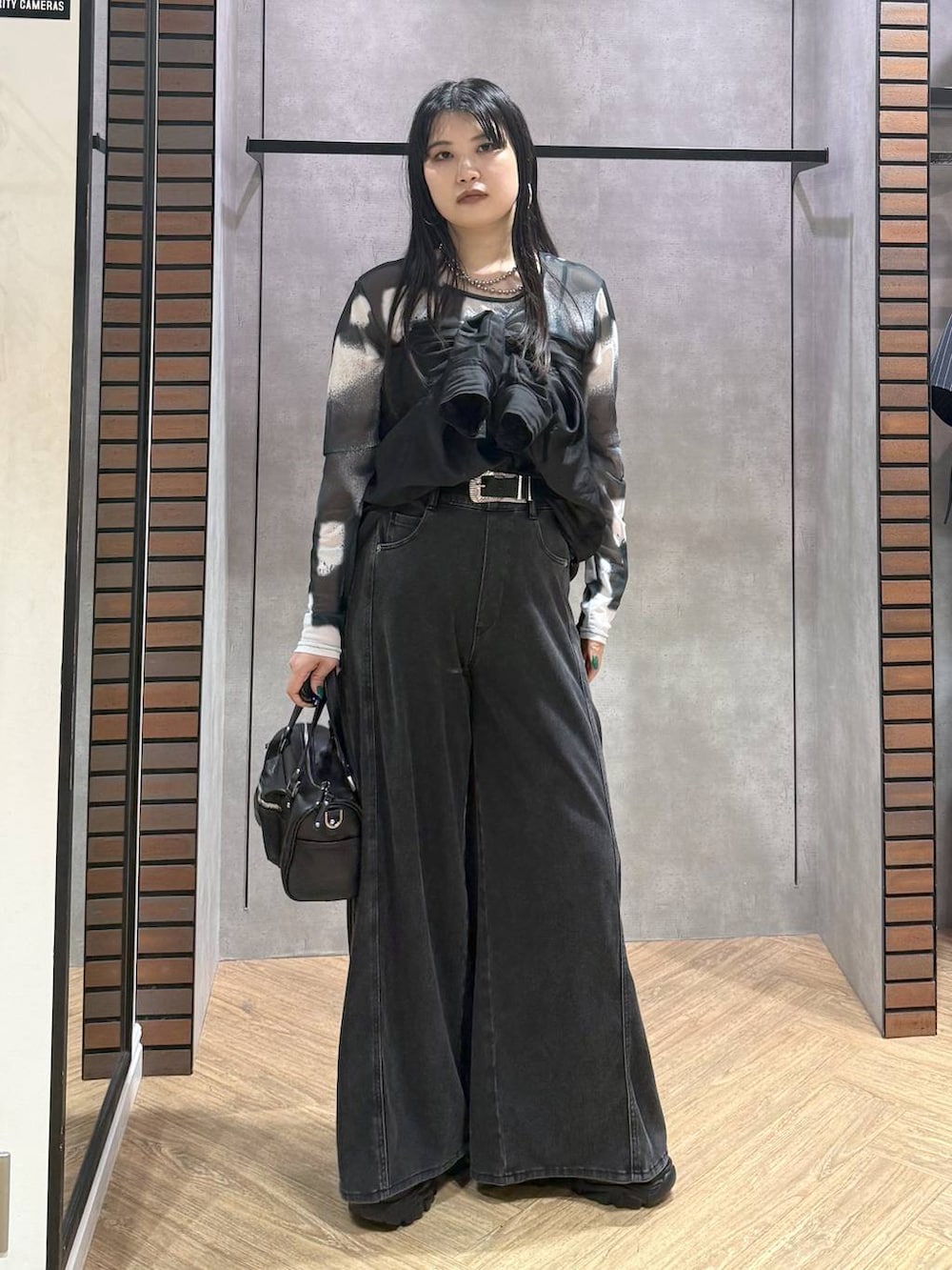 ブラック系のデニムパンツ、ブラック系のショルダーバッグ、グレー系のその他トップスを着用したレディースの夏コーディネートの4枚目の写真