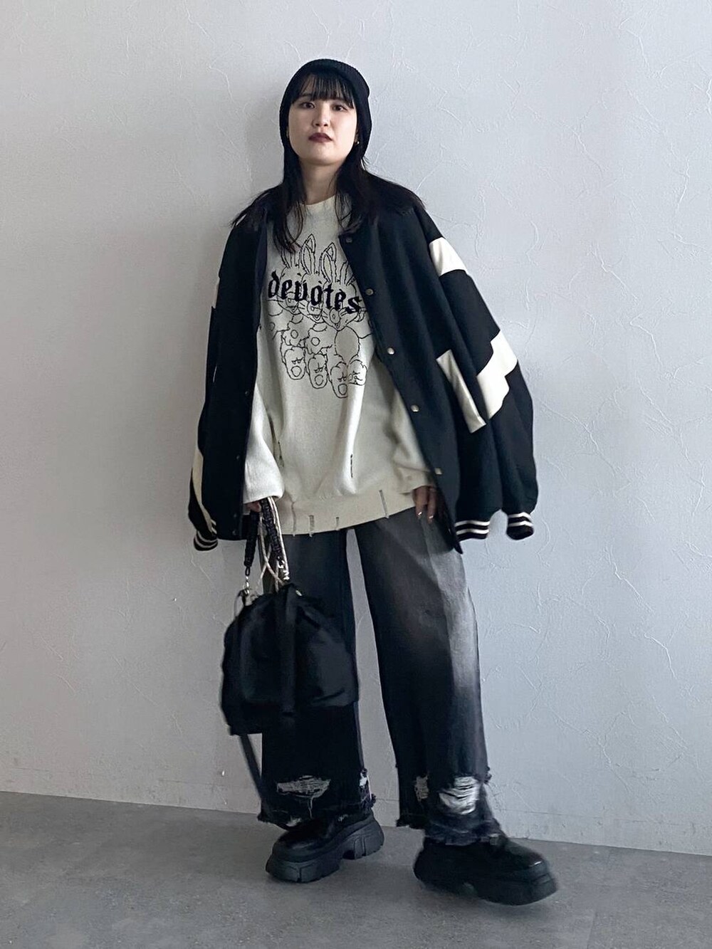 ブラック系のデニムパンツ、ブラック系のスタジャン、ブラック系のショルダーバッグを着用したレディースの秋コーディネートの5枚目の写真