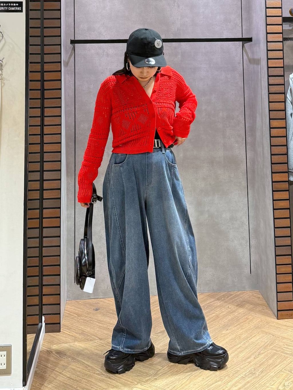 ブラック系のキャミソール、ブルー系のデニムパンツ、ブラック系のショルダーバッグを着用したレディースの春コーディネートの6枚目の写真