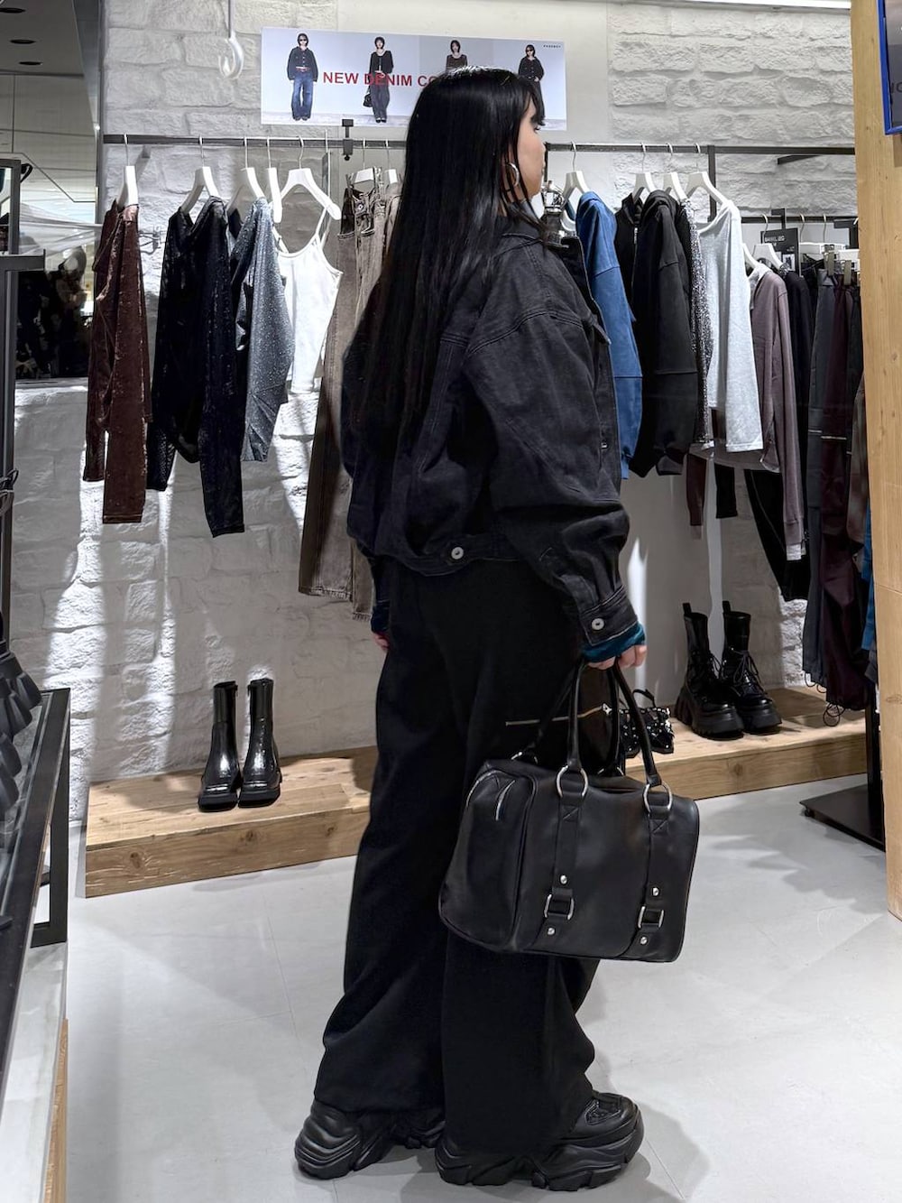 ブラック系のカーゴパンツ、ブラック系のデニムジャケット、ブラック系のスニーカーを着用したレディースの秋コーディネートの4枚目の写真