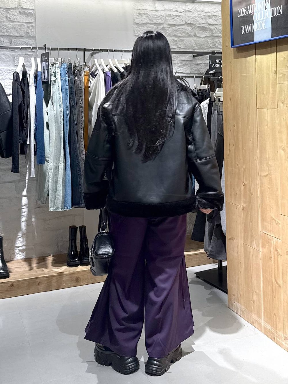 ブラック系のライダースジャケット、パープル系のその他パンツ、ブラック系のショルダーバッグを着用したレディースの秋コーディネートの4枚目の写真