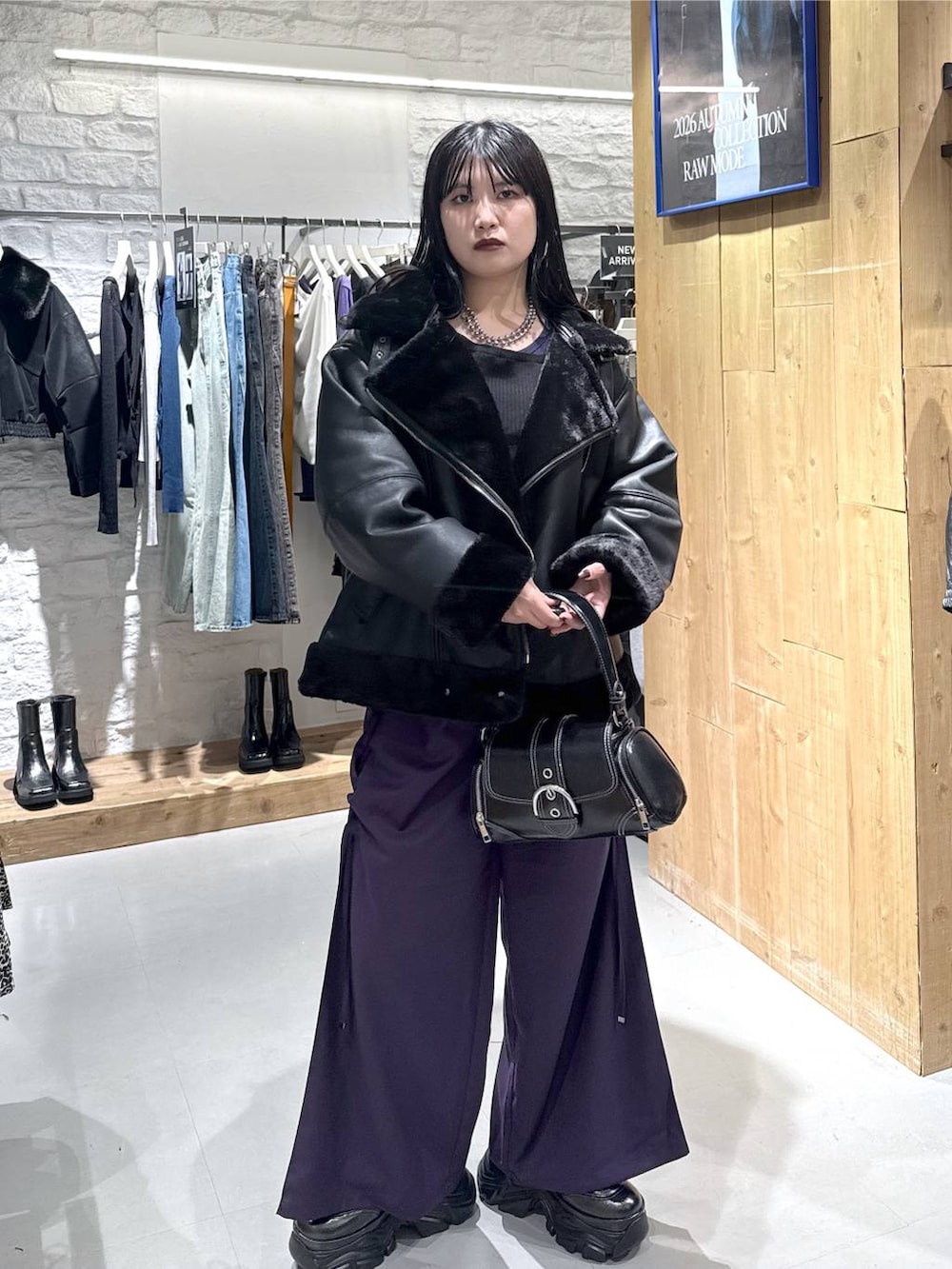 ブラック系のライダースジャケット、パープル系のその他パンツ、ブラック系のショルダーバッグを着用したレディースの秋コーディネートの5枚目の写真