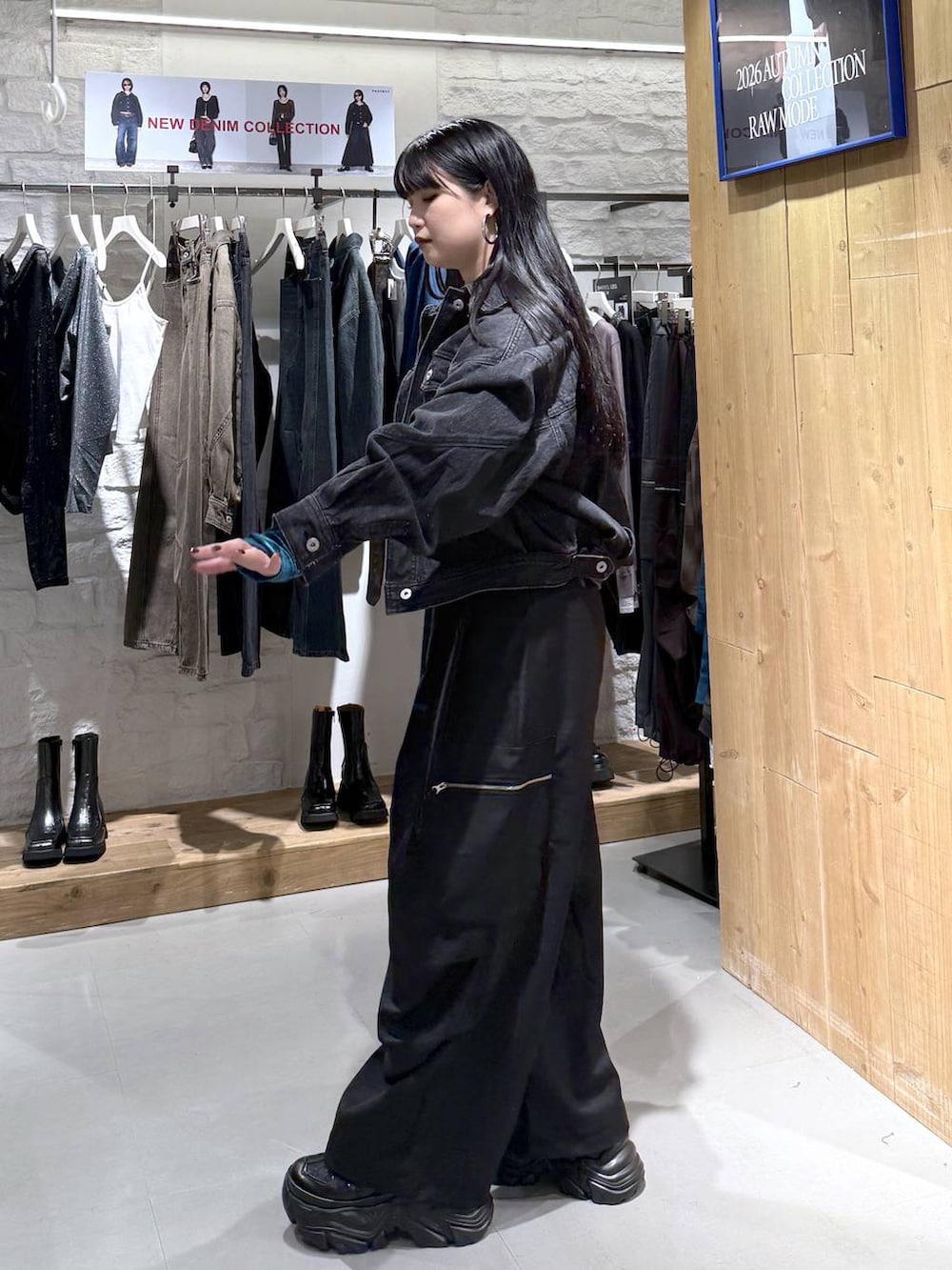 ブラック系のカーゴパンツ、ブラック系のデニムジャケット、ブラック系のスニーカーを着用したレディースの秋コーディネートの2枚目の写真