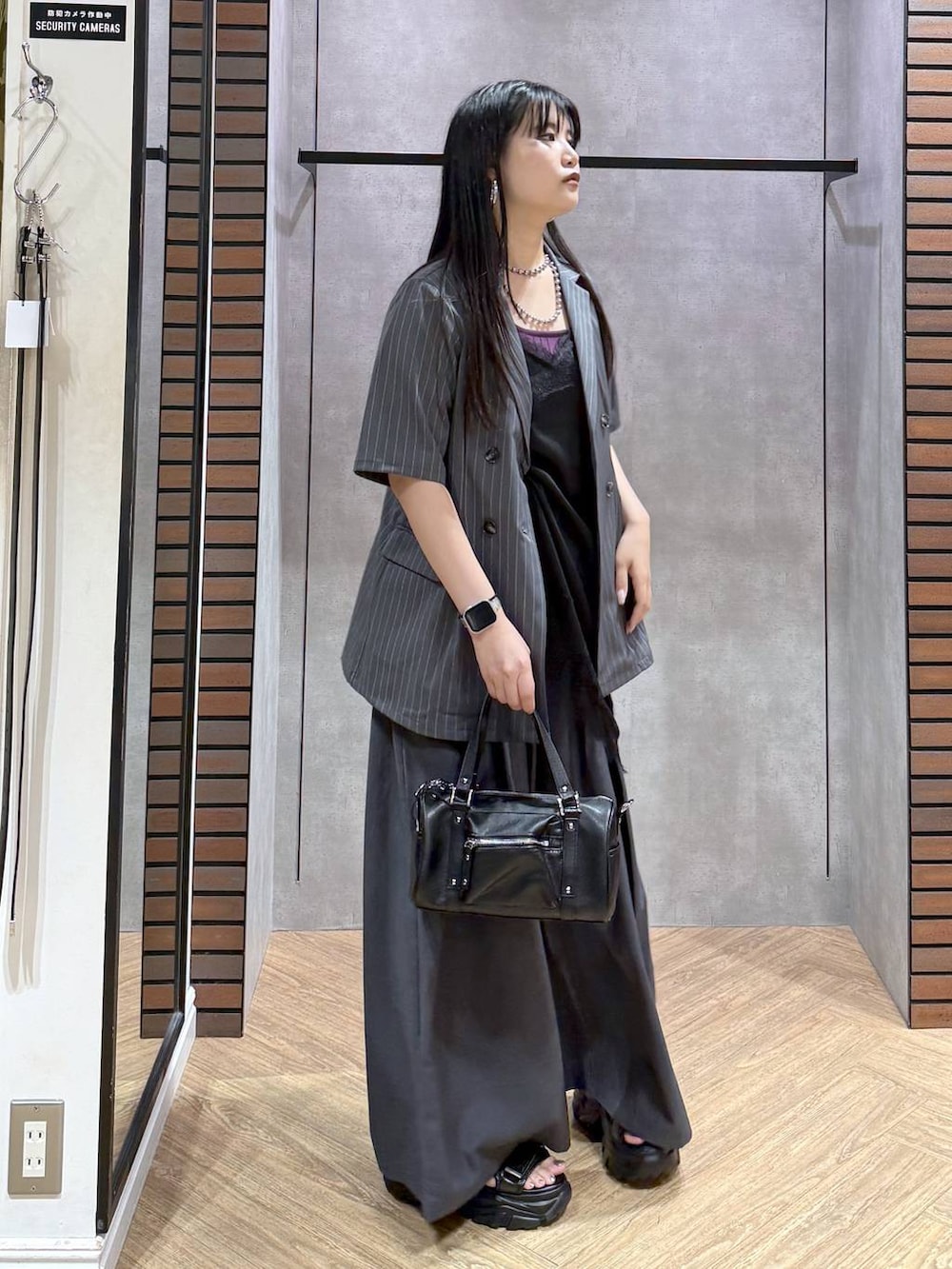 ブラック系のデニムパンツ、ブラック系のショルダーバッグ、ブラック系のチュニックを着用したレディースの夏コーディネートの4枚目の写真