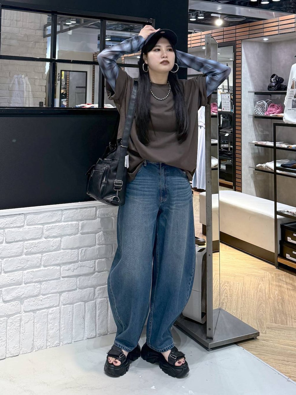 ブラウン系のショルダーバッグ、ブラック系のサンダル、ブラウン系のTシャツ/カットソーを着用したレディースの夏コーディネートの5枚目の写真