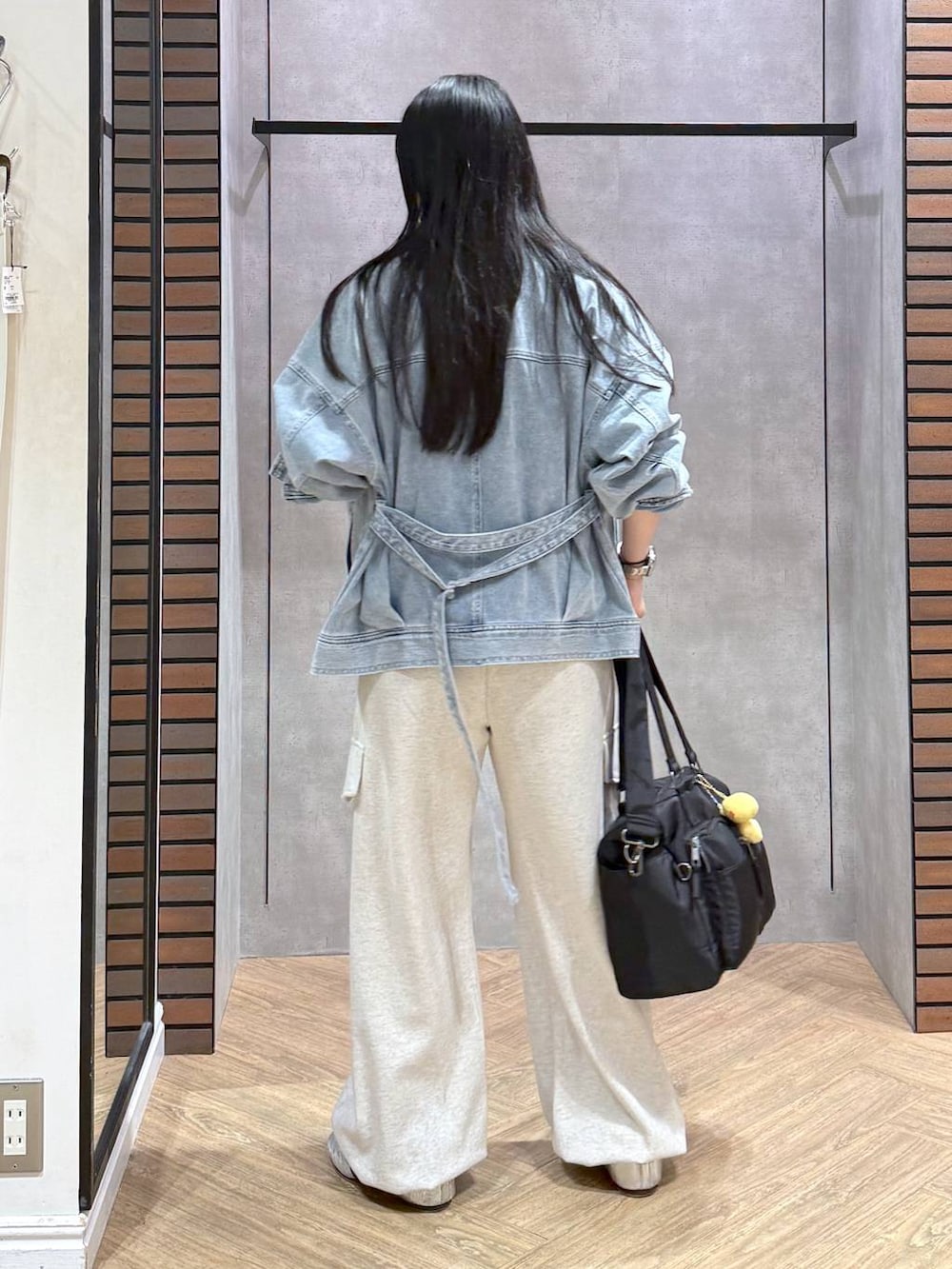 ブラック系のボストンバッグ、ブルー系のブルゾン、ベージュ系のその他パンツを着用したレディースの春コーディネートの3枚目の写真