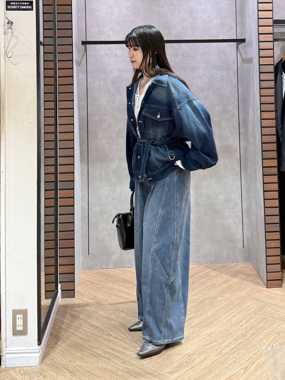 ブルー系のブルゾン、グレー系のショルダーバッグ、ホワイト系のタンクトップを着用したレディースの春コーディネートの3枚目の写真