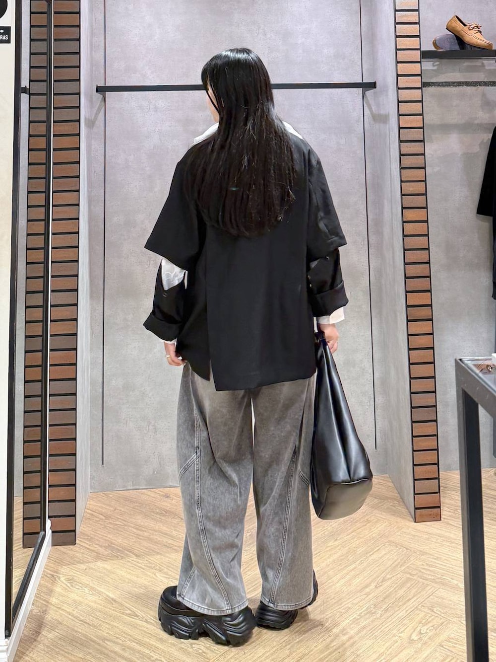 ブラック系のブーツ、ブラック系のキャミソール、ブラック系のデニムパンツを着用したレディースの春コーディネートの3枚目の写真