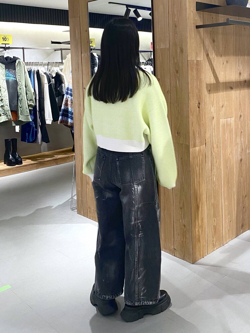 ブラック系のブーツ、ホワイト系のニット/セーター、ブラック系のショルダーバッグを着用したレディースの冬コーディネートの6枚目の写真