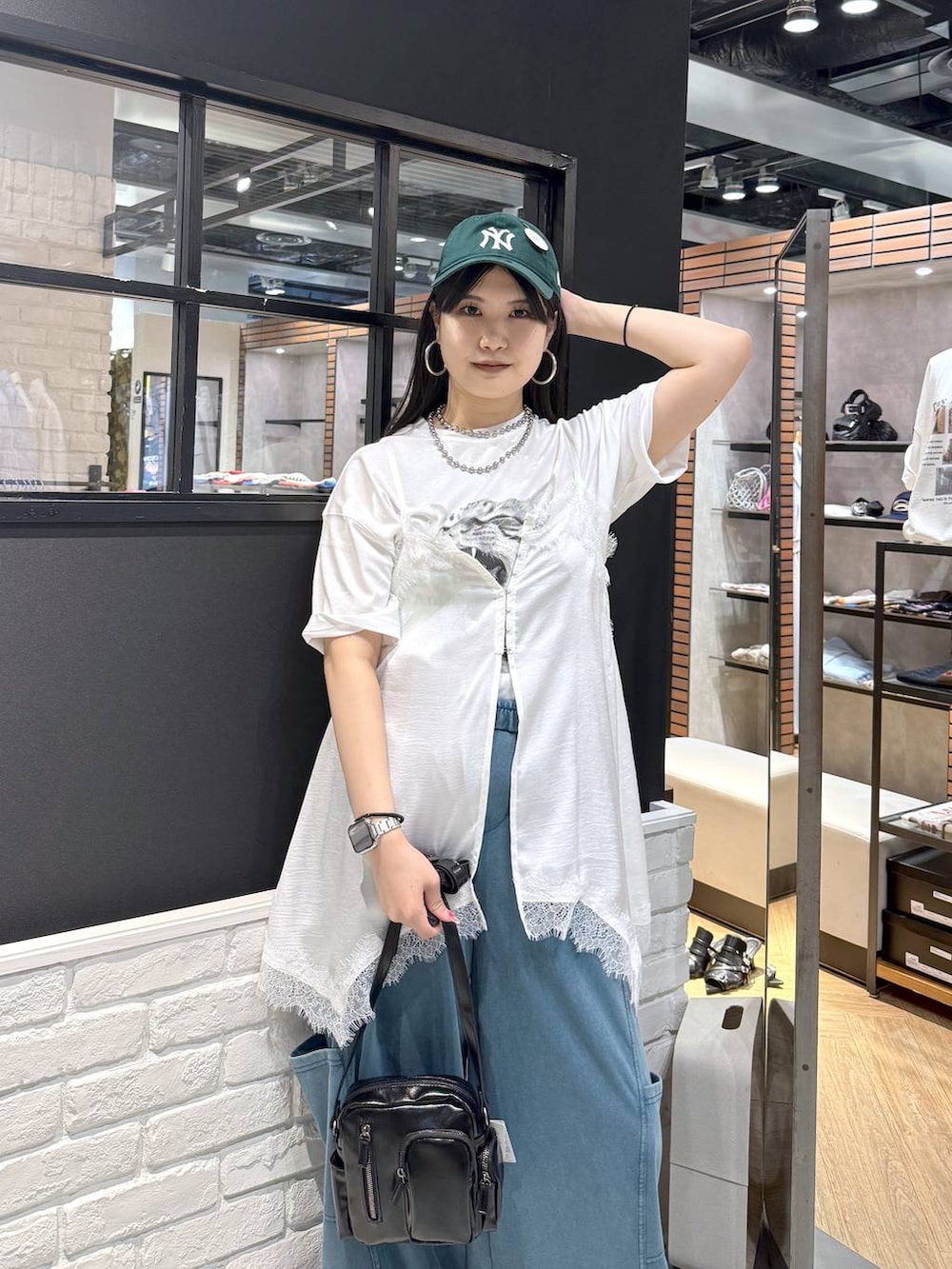 ブラック系のショルダーバッグ、ブラック系のサンダル、ホワイト系のTシャツ/カットソーを着用したレディースの春コーディネートの2枚目の写真