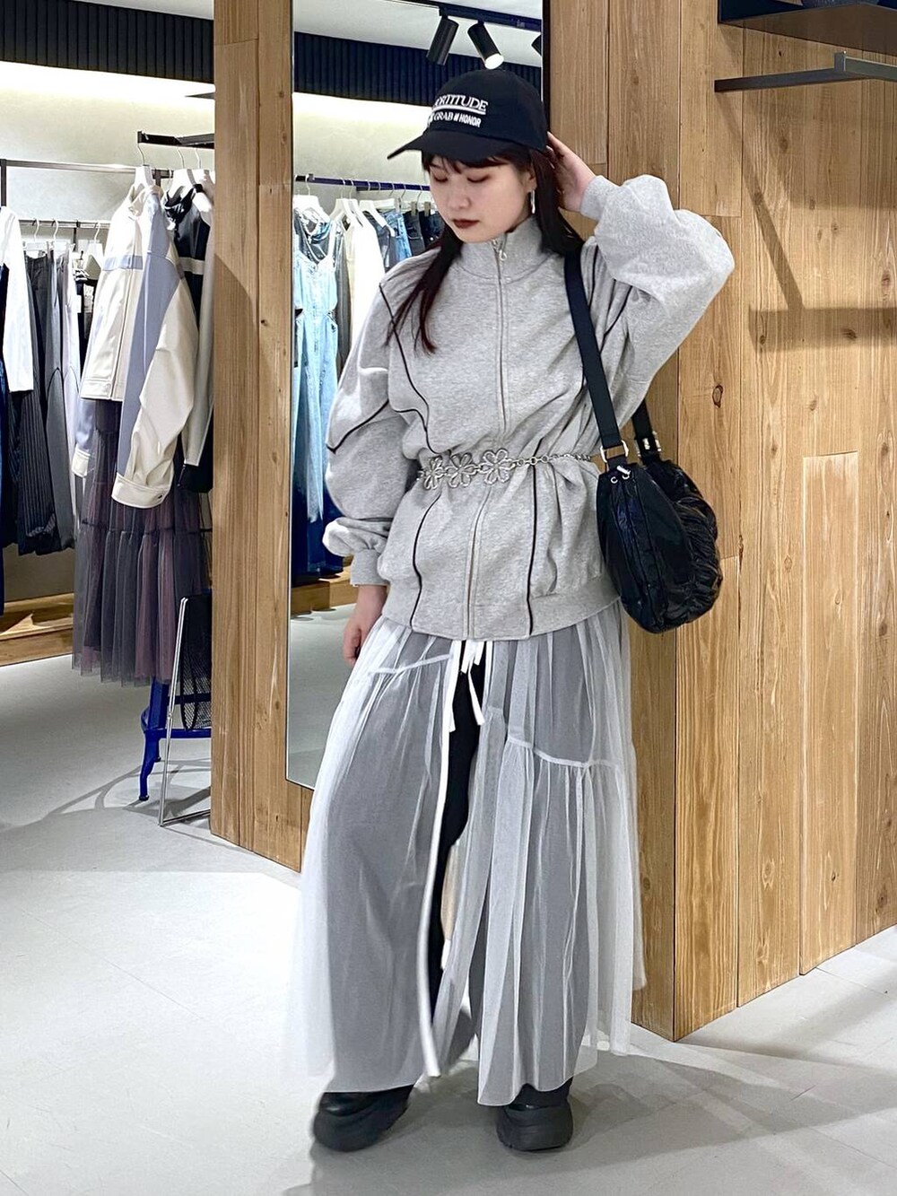 ブラック系のショルダーバッグ、グレー系のスウェット、ホワイト系のワンピースを着用したレディースの春コーディネートの5枚目の写真