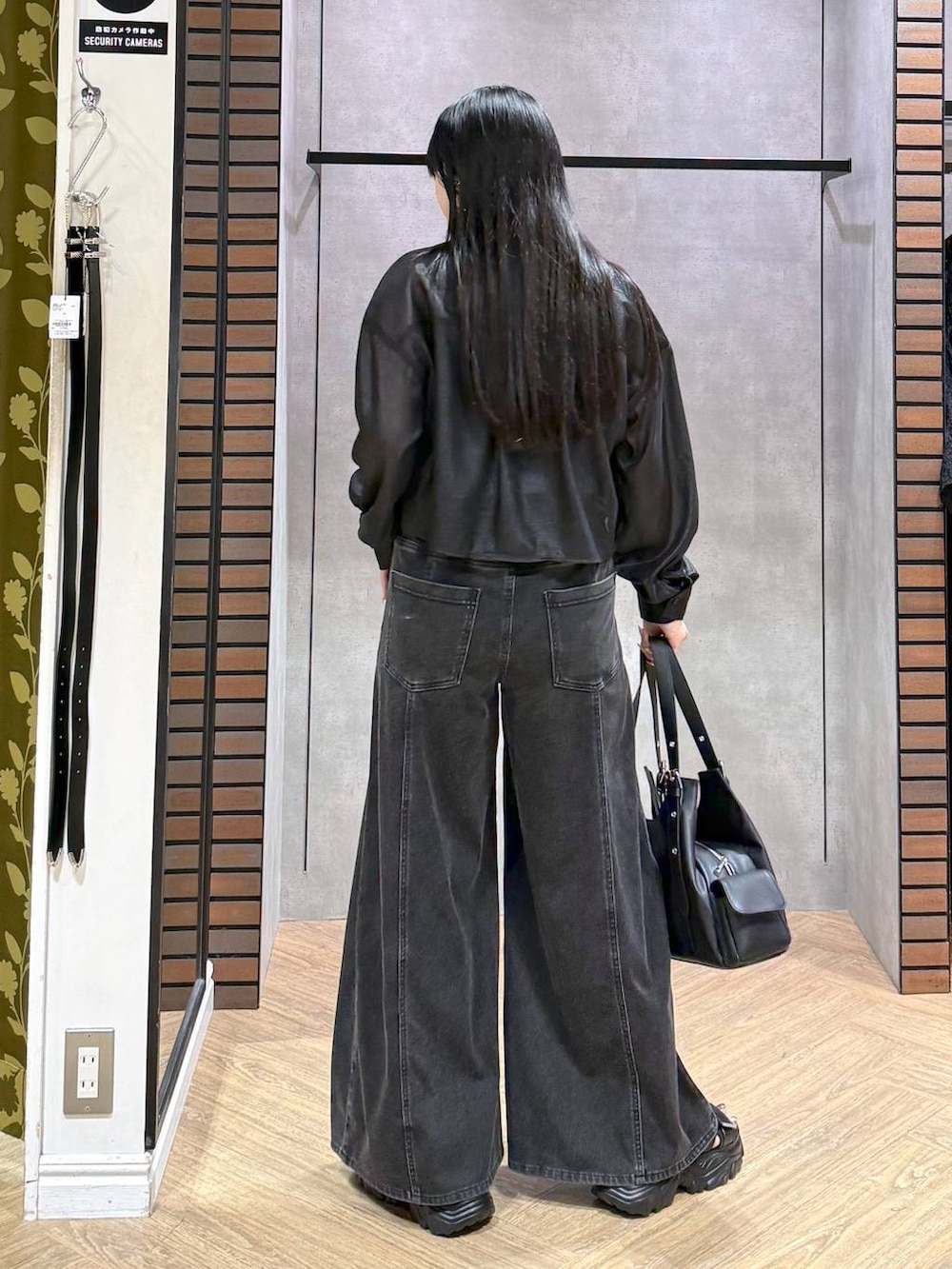 ブラック系のデニムパンツ、ブルー系のタンクトップ、ブラック系のサンダルを着用したレディースの夏コーディネートの6枚目の写真