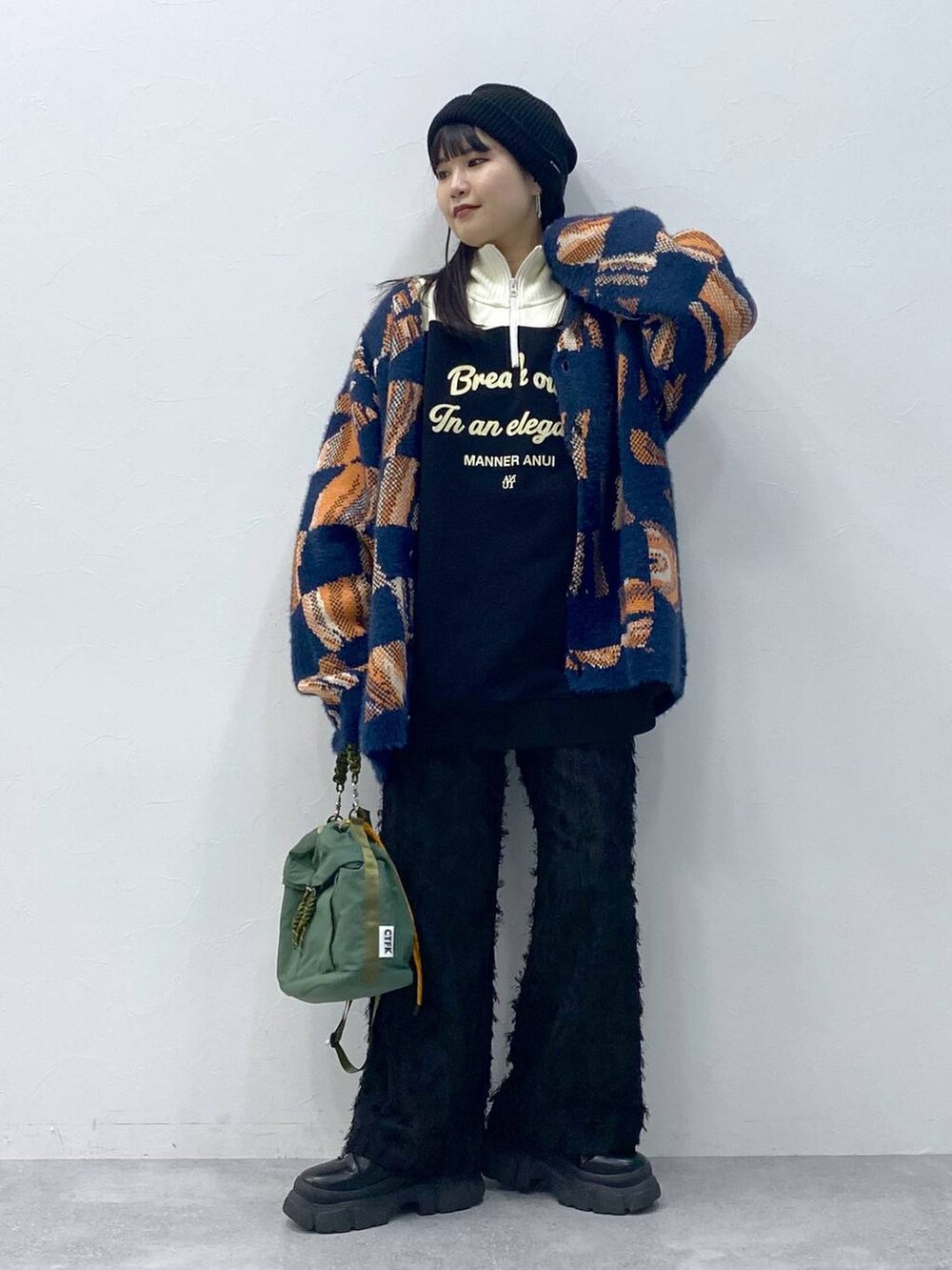 ブラック系のブーツ、ブルー系のニット/セーター、ブラック系のスラックスを着用したレディースの冬コーディネートの4枚目の写真