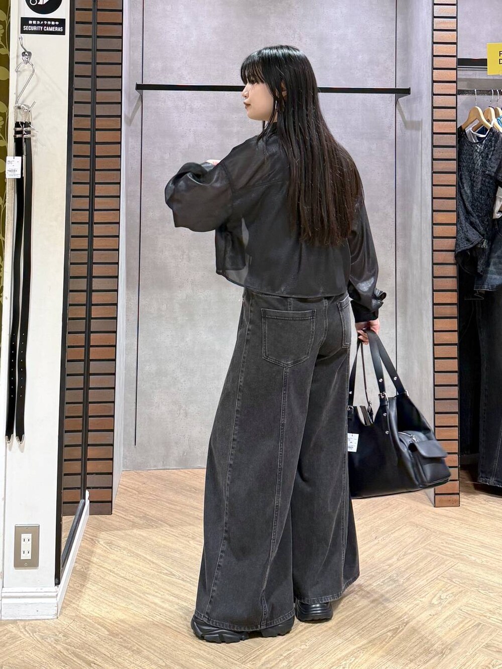 ブラック系のデニムパンツ、ブルー系のタンクトップ、ブラック系のサンダルを着用したレディースの夏コーディネートの3枚目の写真