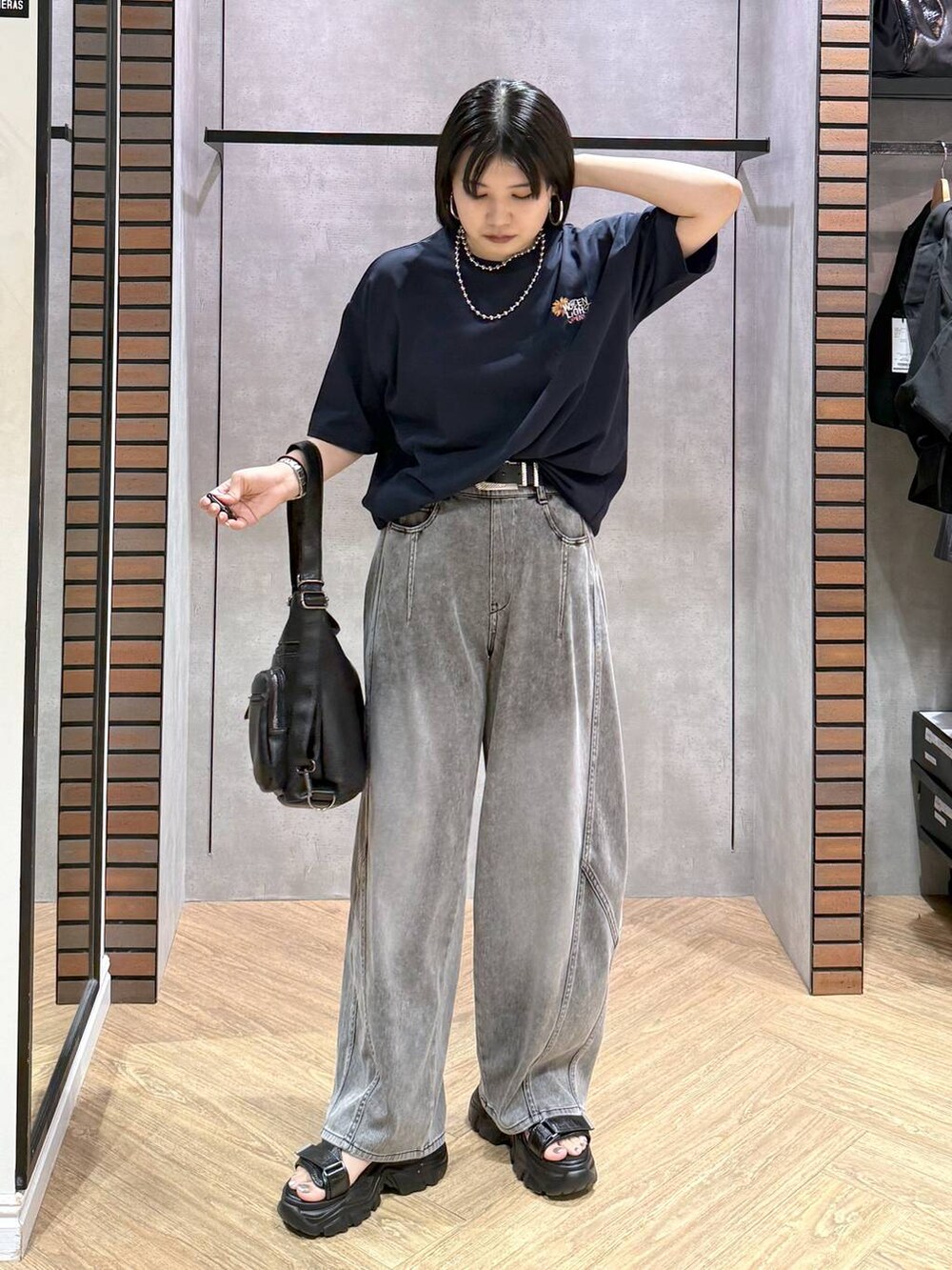 ブラック系のショルダーバッグ、ブラック系のデニムパンツ、ブラック系のサンダルを着用したレディースの夏コーディネートの5枚目の写真