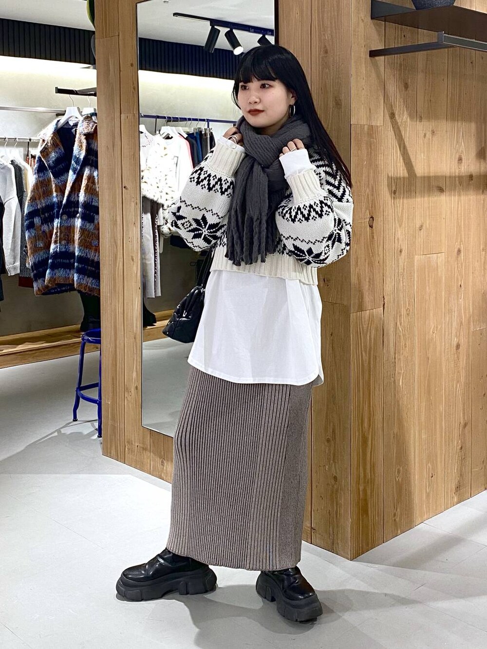 ブラック系のブーツ、ホワイト系のTシャツ/カットソー、ブラック系のショルダーバッグを着用したレディースの冬コーディネートの2枚目の写真