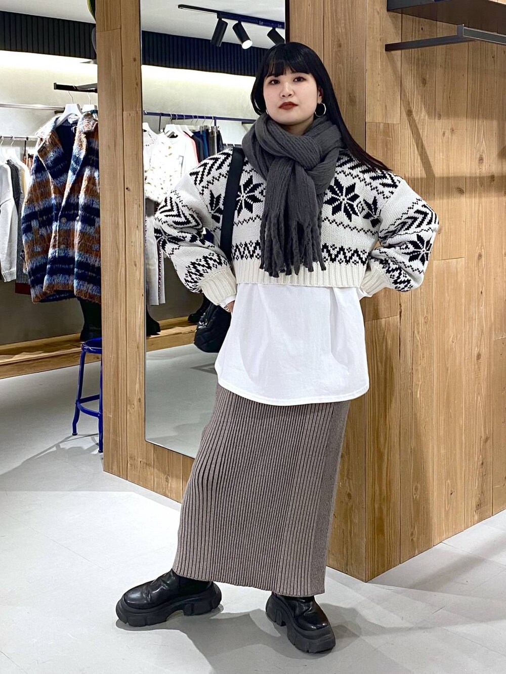 ブラック系のブーツ、ホワイト系のTシャツ/カットソー、ブラック系のショルダーバッグを着用したレディースの冬コーディネートの5枚目の写真