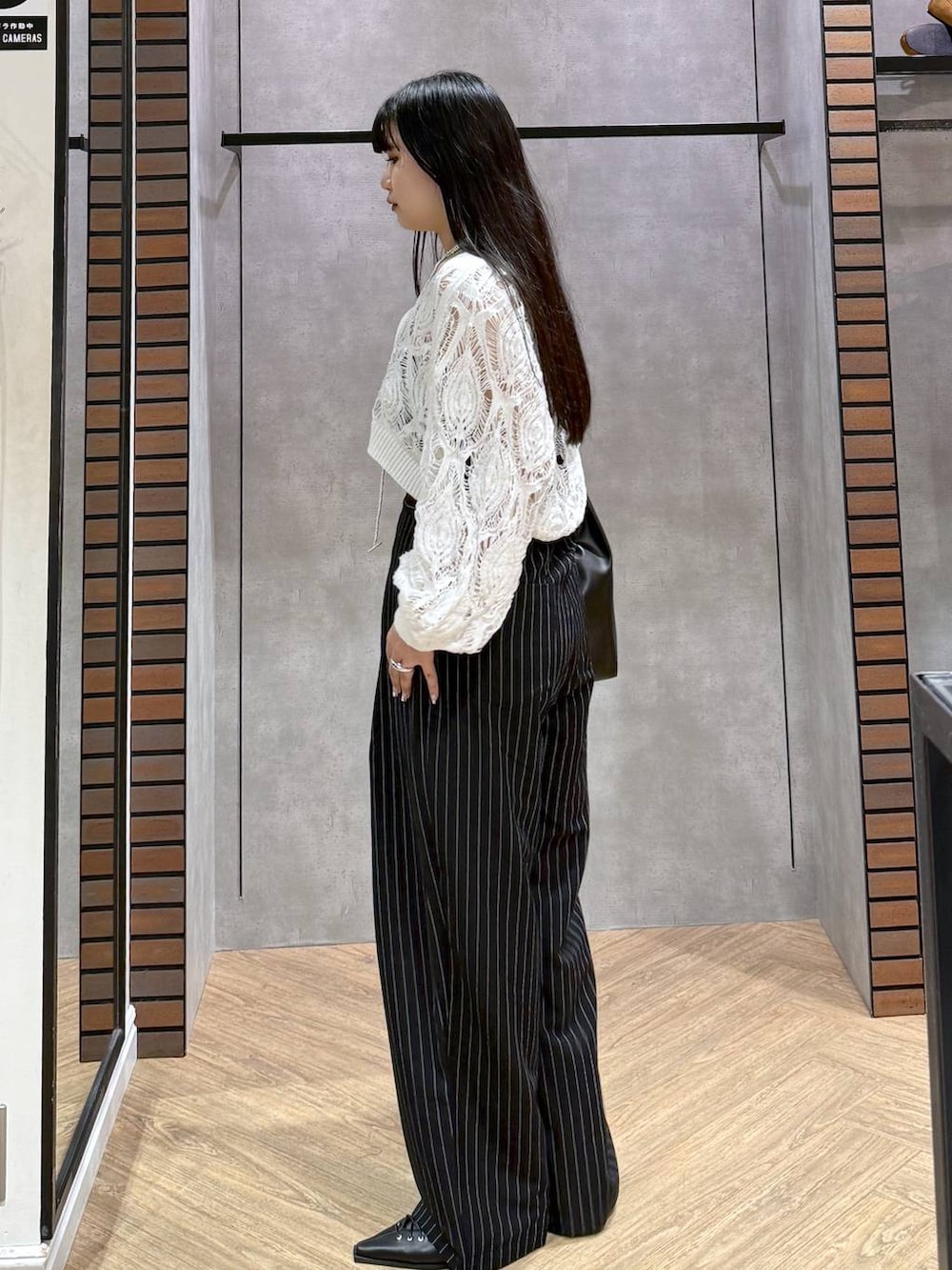 ブラック系のキャミソール、ホワイト系のカーディガン/ボレロ、ブラック系のトートバッグを着用したレディースの春コーディネートの6枚目の写真