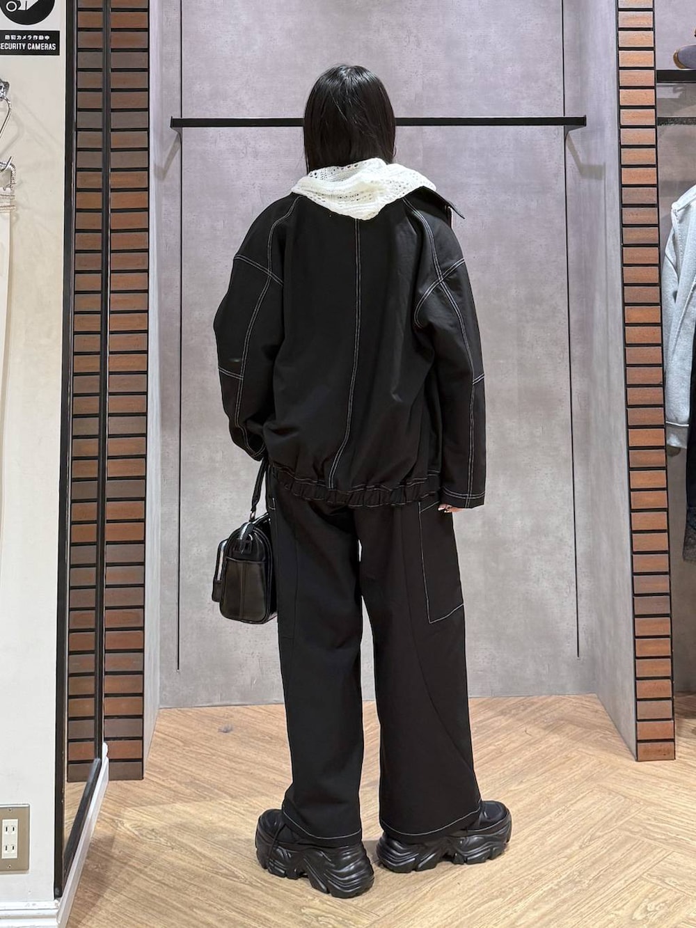 ブラック系のスニーカー、ブラック系のショルダーバッグ、ブルー系のタンクトップを着用したレディースの春コーディネートの5枚目の写真