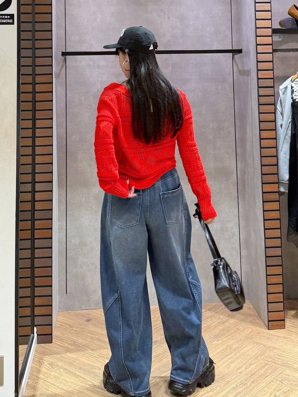 ブラック系のキャミソール、ブルー系のデニムパンツ、ブラック系のショルダーバッグを着用したレディースの春コーディネートの3枚目の写真