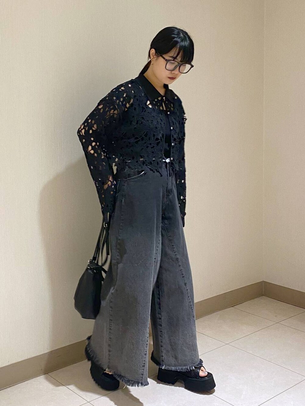 ブラック系のタンクトップ、ブラック系のショルダーバッグ、ブラック系のデニムパンツを着用したレディースの夏コーディネートの4枚目の写真