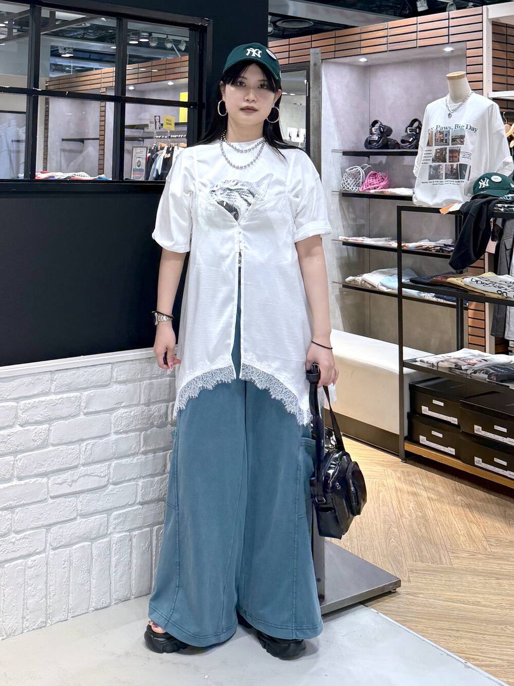 ブラック系のショルダーバッグ、ブラック系のサンダル、ホワイト系のTシャツ/カットソーを着用したレディースの春コーディネートの5枚目の写真