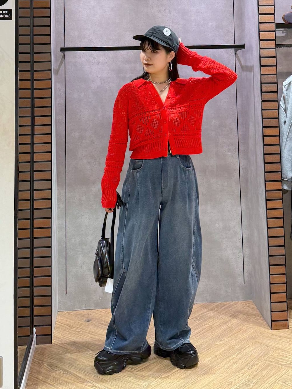 ブラック系のキャミソール、ブルー系のデニムパンツ、ブラック系のショルダーバッグを着用したレディースの春コーディネートの2枚目の写真