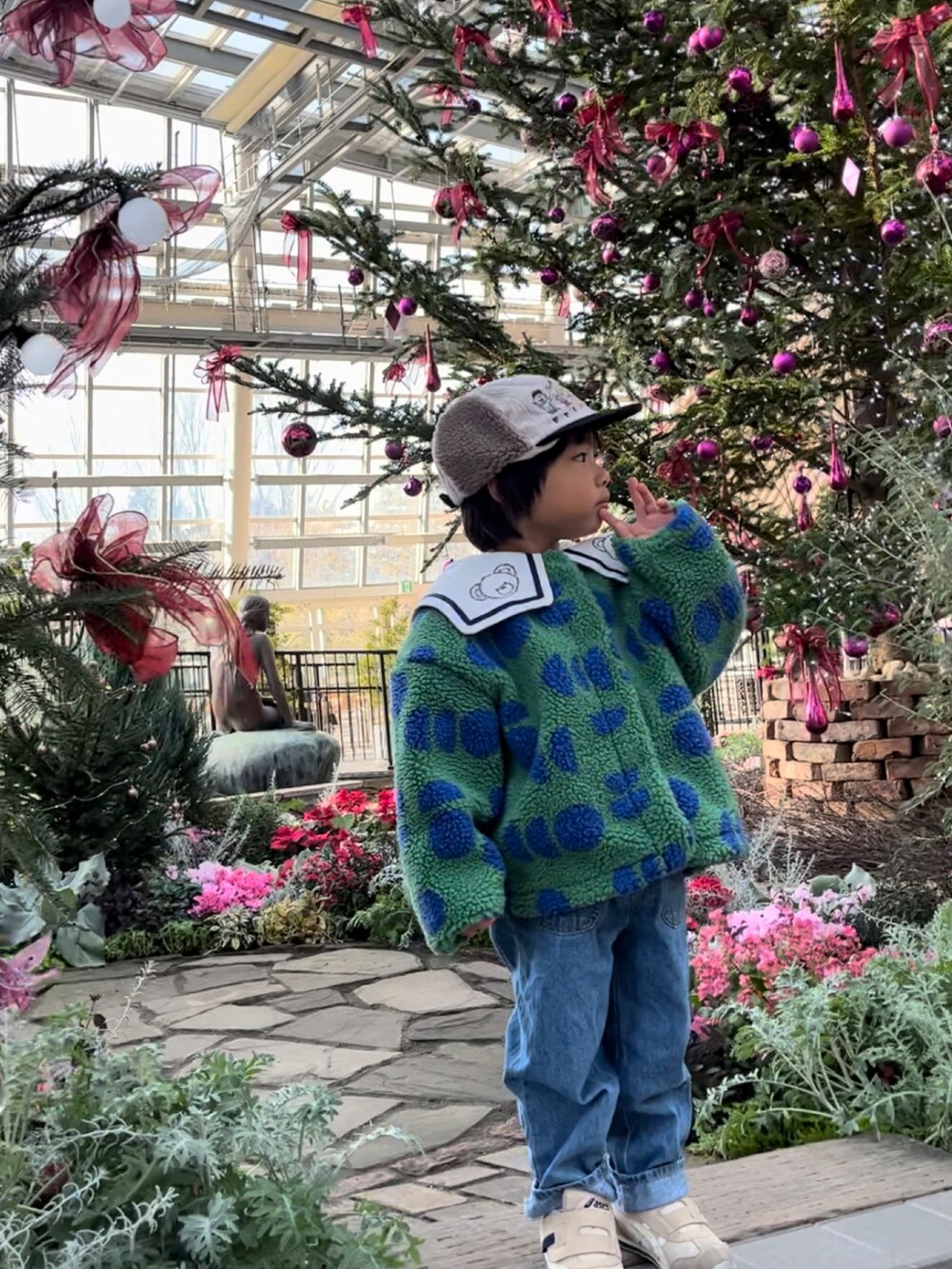 グリーン系のその他アウター、その他のスウェット、ブルー系のデニムパンツを着用したキッズの冬コーディネートの4枚目の写真