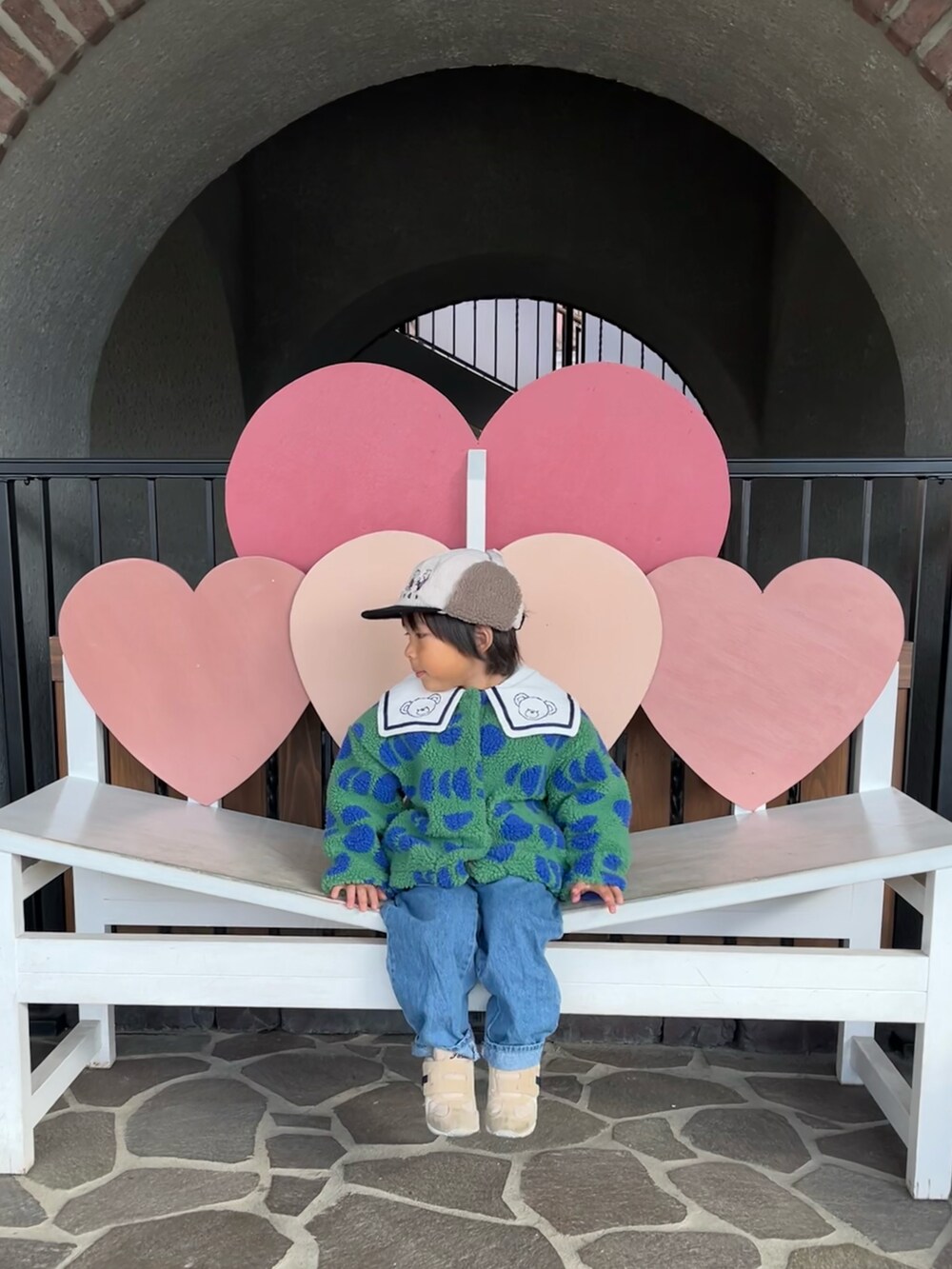 グリーン系のその他アウター、その他のスウェット、ブルー系のデニムパンツを着用したキッズの冬コーディネートの2枚目の写真