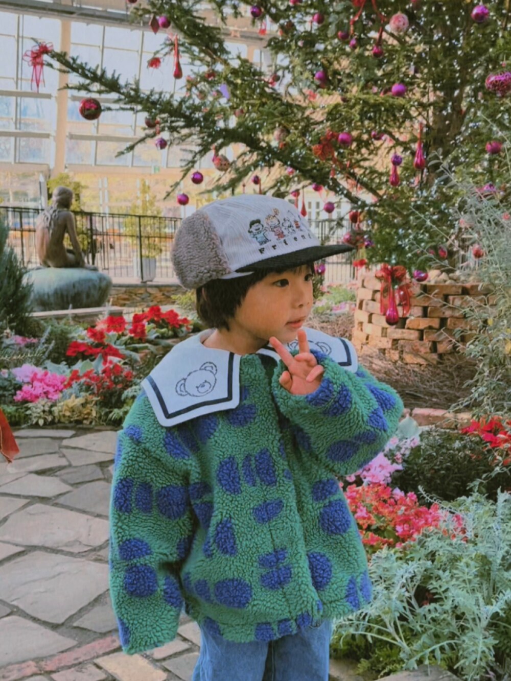 グリーン系のその他アウター、その他のスウェット、ブルー系のデニムパンツを着用したキッズの冬コーディネートの3枚目の写真