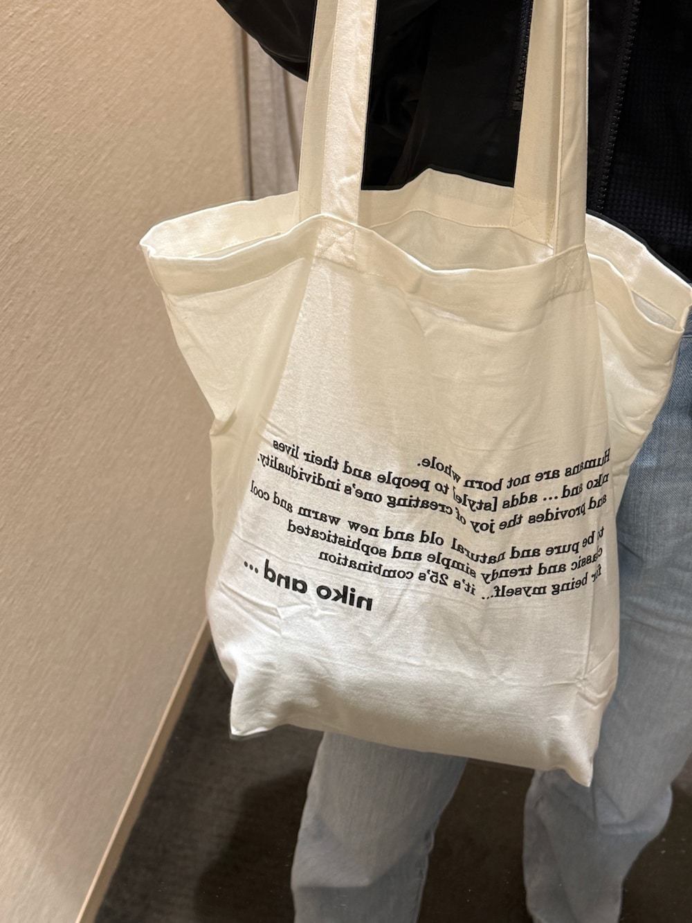 ベージュ系のトートバッグを着用したレディースの春コーディネートの2枚目の写真