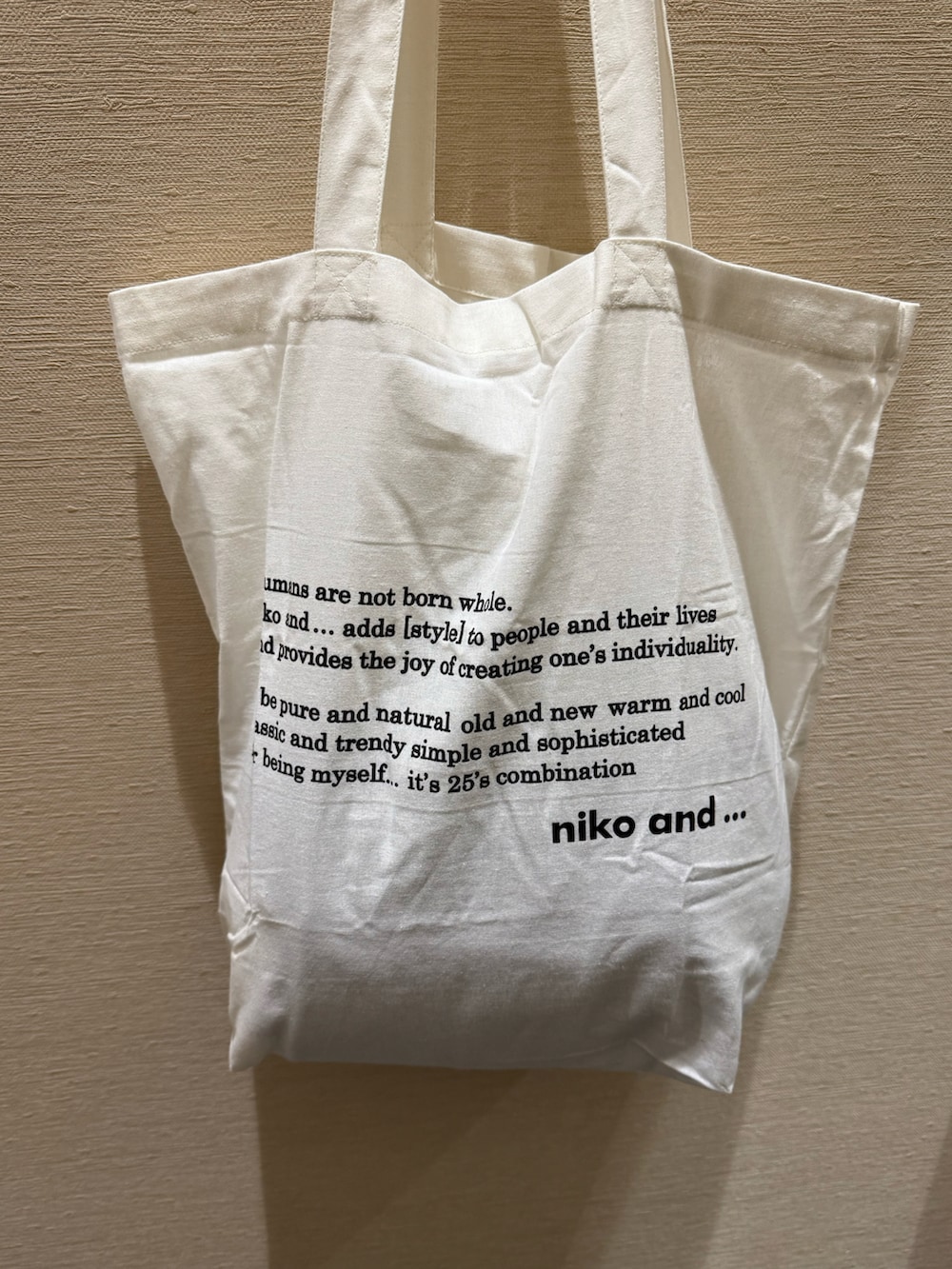 ベージュ系のトートバッグを着用したレディースの春コーディネートの3枚目の写真