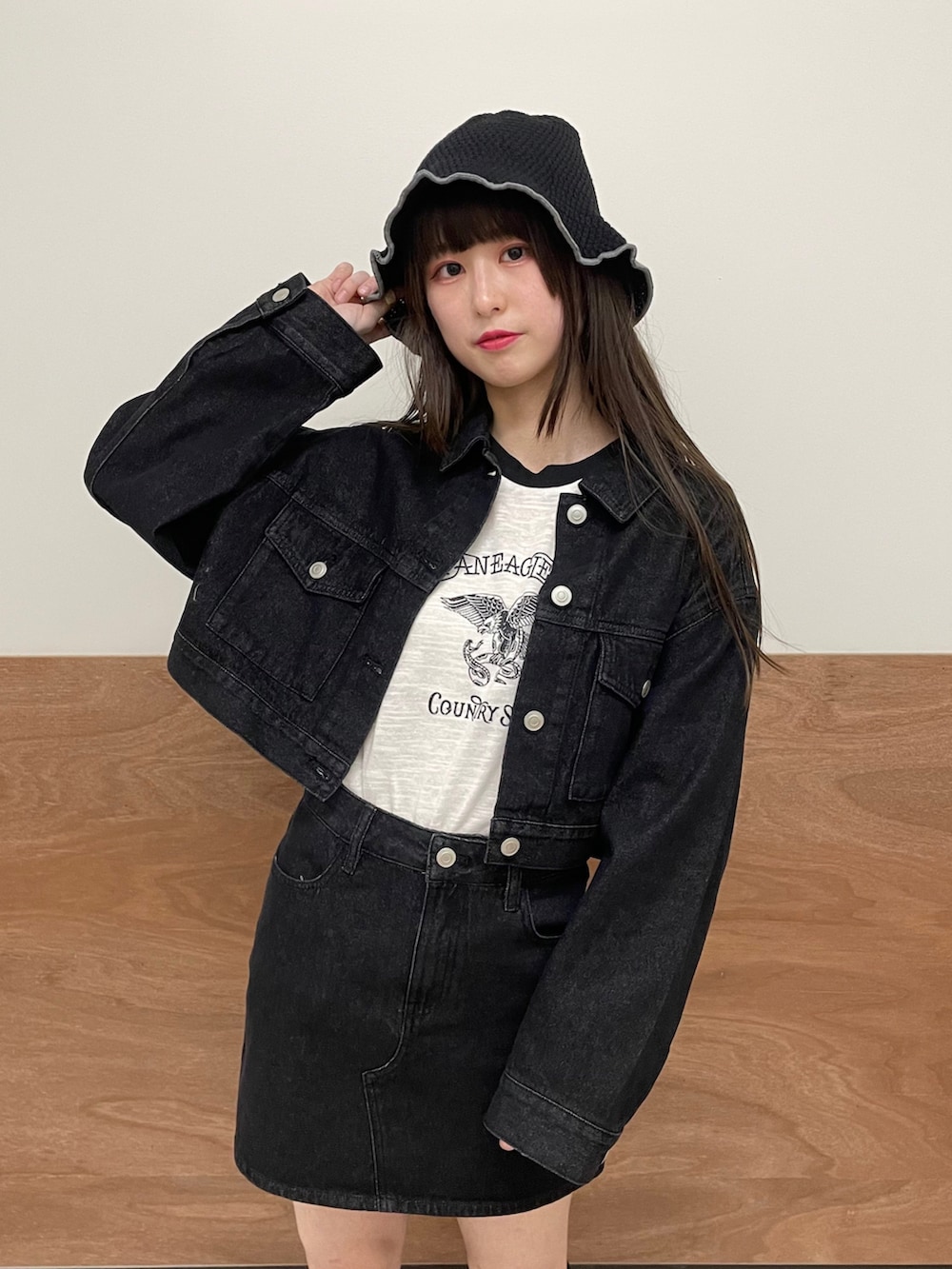 ブラック系のデニムスカート、ブラック系のデニムジャケット、ホワイト系のTシャツ/カットソーを着用したレディースの春コーディネートの5枚目の写真