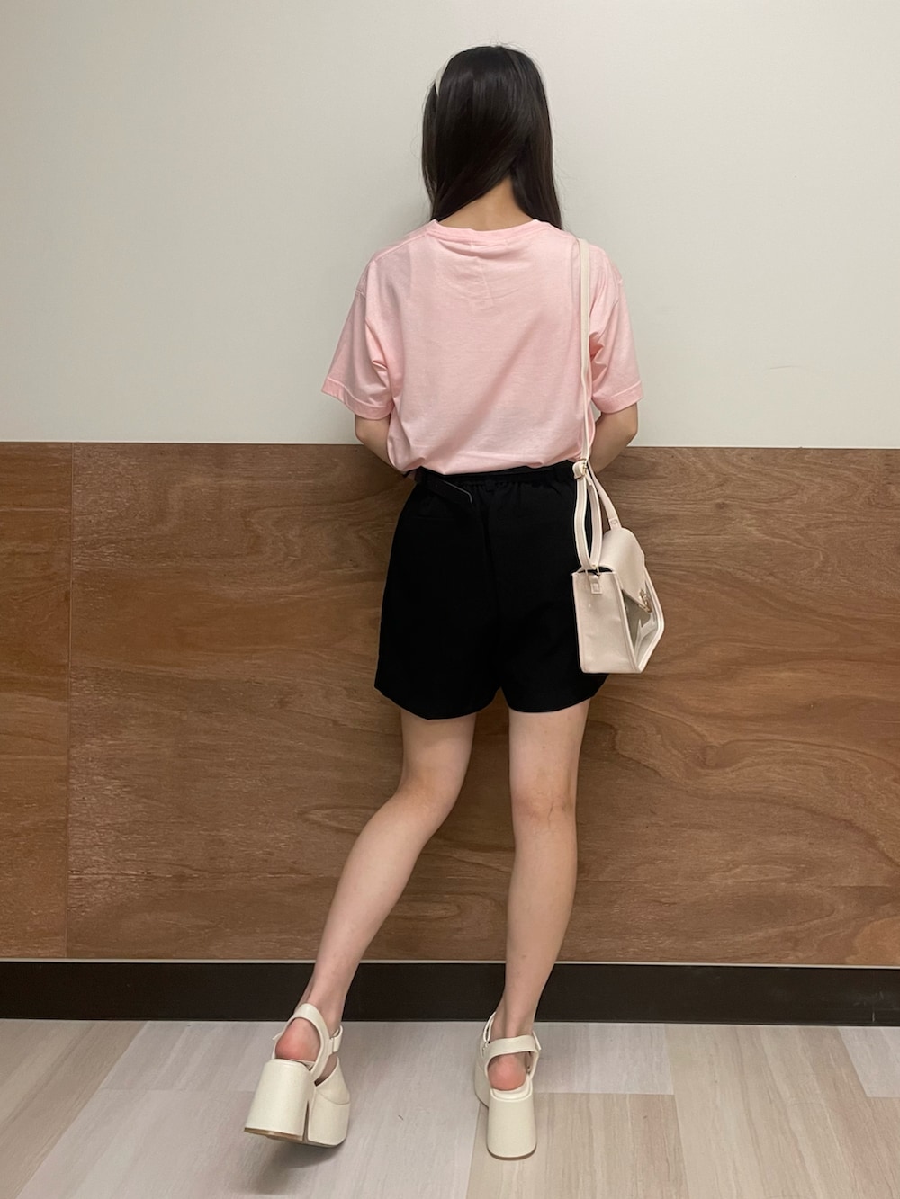 ホワイト系のサンダル、ブラック系のスラックス、ホワイト系のショルダーバッグを着用したレディースの夏コーディネートの3枚目の写真