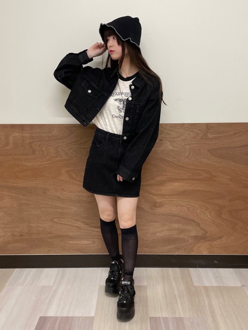 ブラック系のデニムスカート、ブラック系のデニムジャケット、ホワイト系のTシャツ/カットソーを着用したレディースの春コーディネートの2枚目の写真