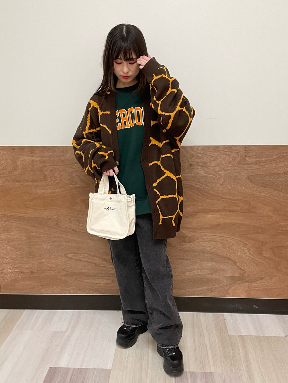 ブラック系のデニムパンツ、その他のショルダーバッグ、グリーン系のスウェットを着用したレディースの春コーディネートの2枚目の写真