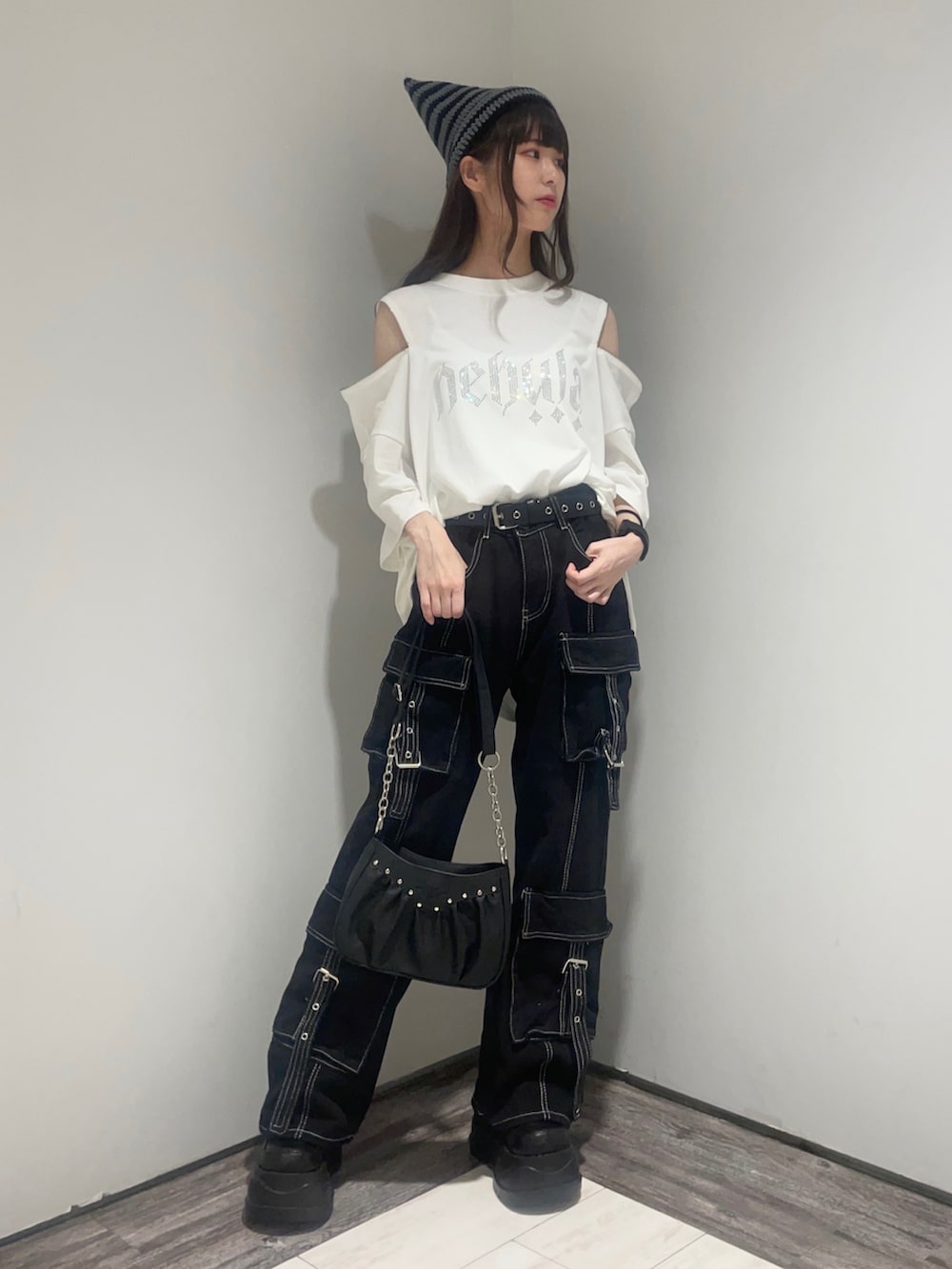 ブラック系のショルダーバッグ、ブラック系のスニーカー、ブラック系のカーゴパンツを着用したレディースの夏コーディネートの2枚目の写真