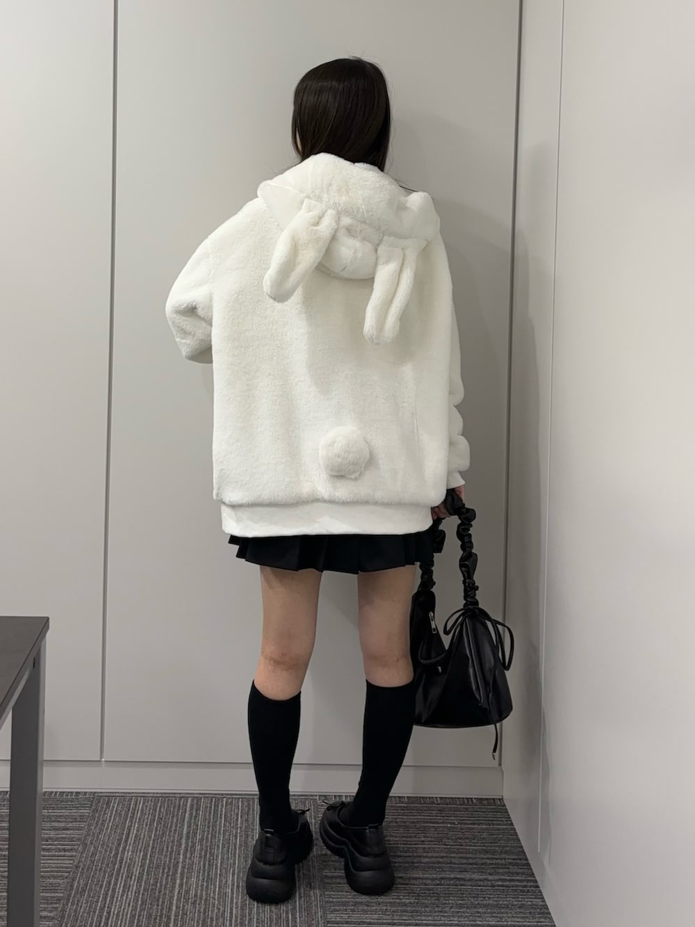 ブラック系のドレスシューズ、ブラック系のショルダーバッグ、ブラック系のスカートを着用したレディースの秋コーディネートの4枚目の写真