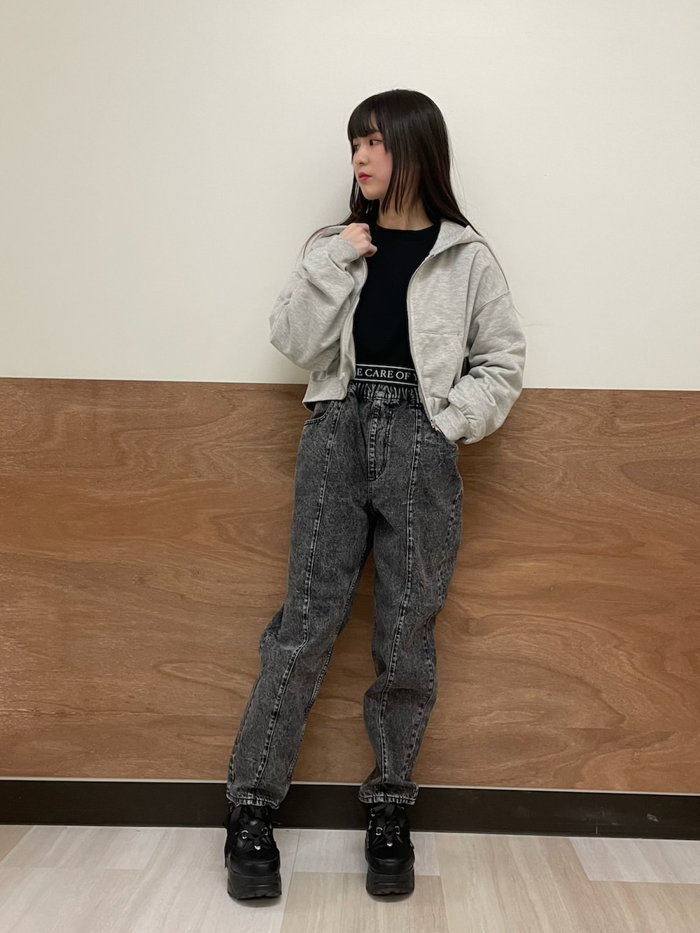 グレー系のパーカー、ブラック系のスウェット、ブラック系のデニムパンツを着用したレディースの冬コーディネートの2枚目の写真