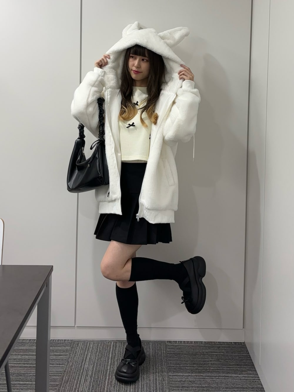 ブラック系のドレスシューズ、ブラック系のショルダーバッグ、ブラック系のスカートを着用したレディースの秋コーディネートの2枚目の写真