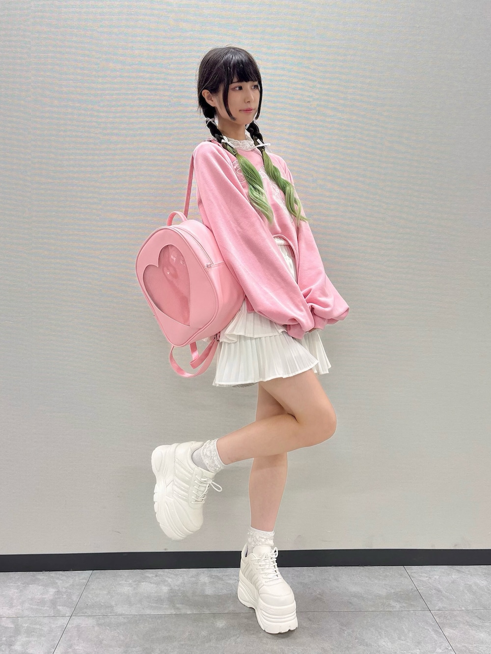 ピンク系のスウェット、ホワイト系のスニーカー、ピンク系のバックパック/リュックを着用したレディースの秋コーディネートの2枚目の写真