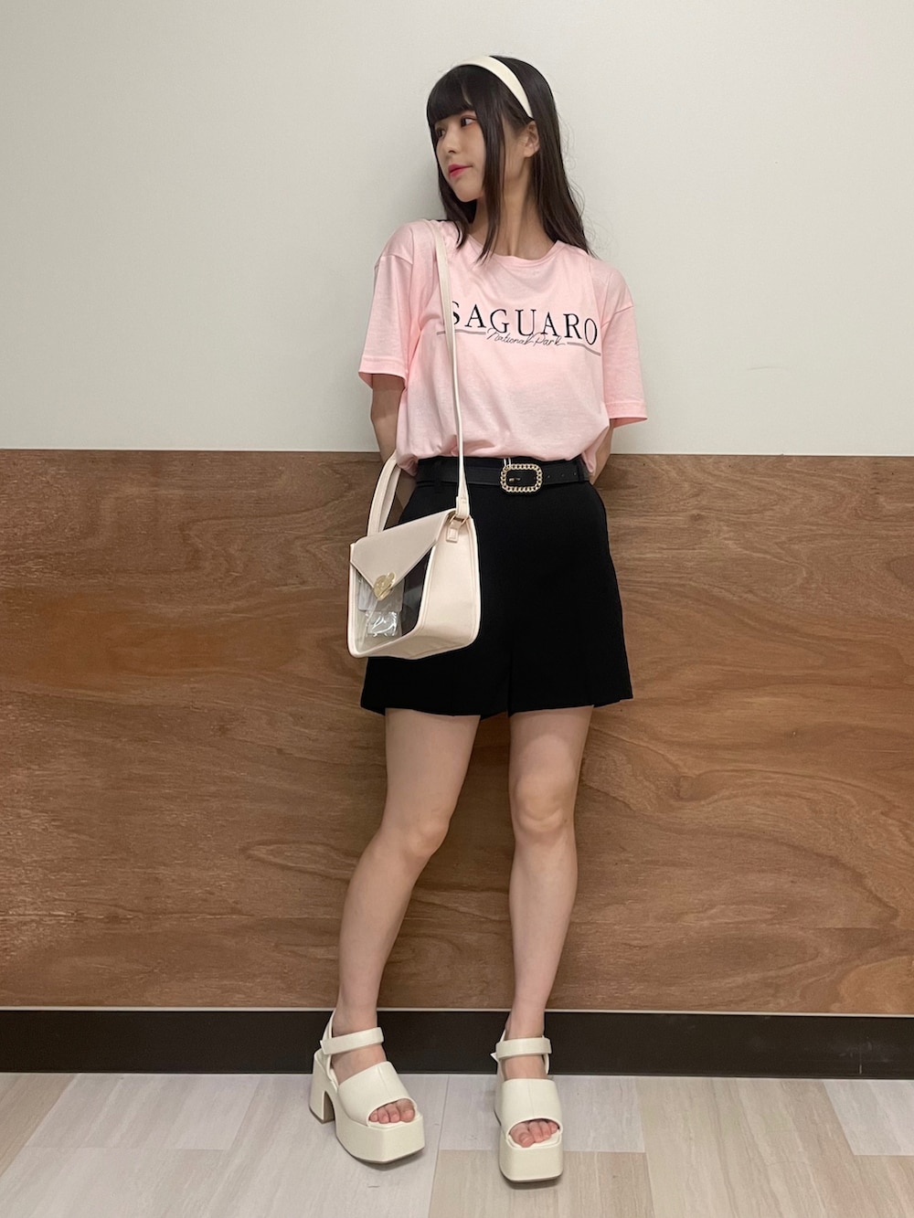 ホワイト系のサンダル、ブラック系のスラックス、ホワイト系のショルダーバッグを着用したレディースの夏コーディネートの2枚目の写真