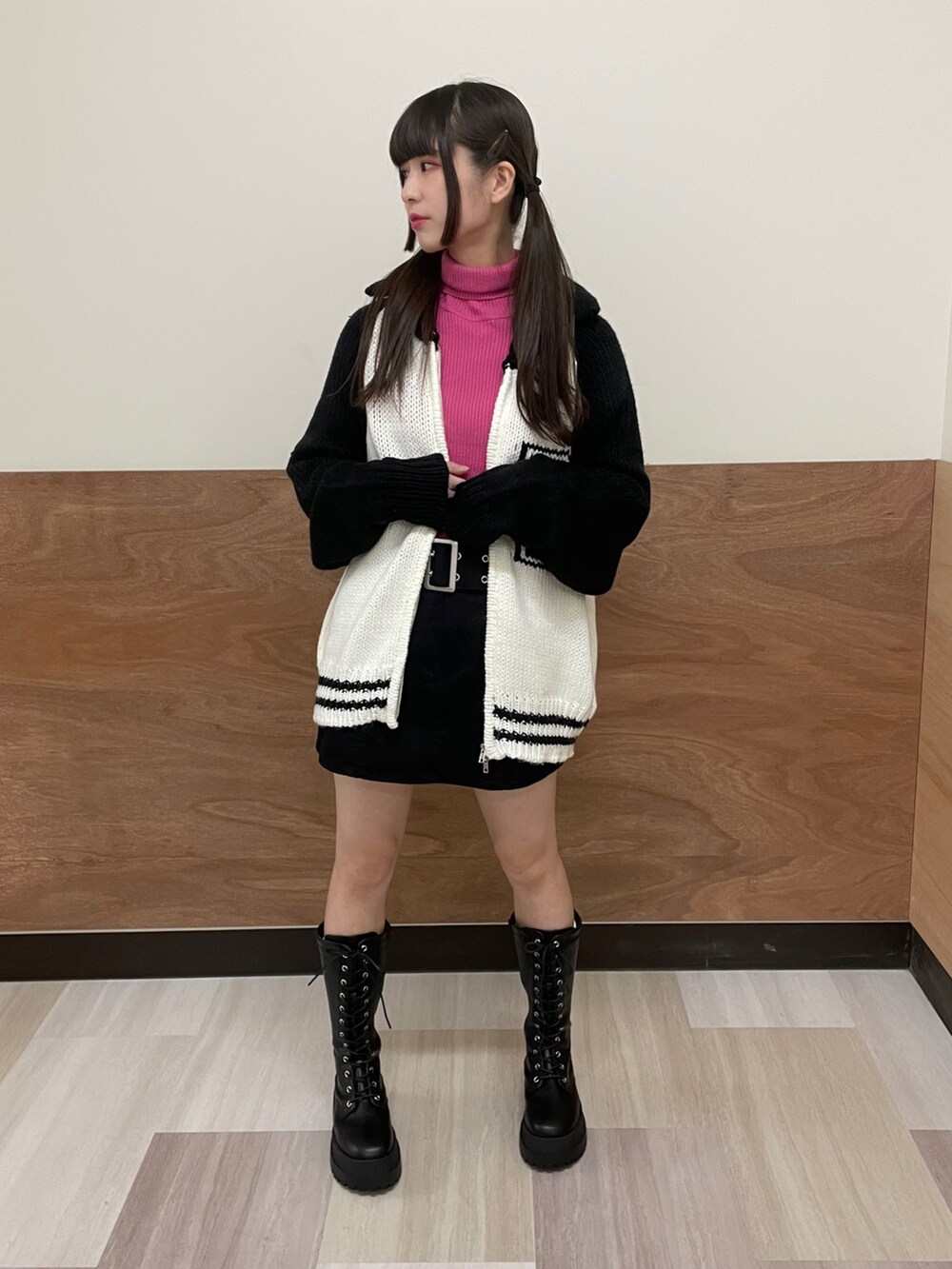 ブラック系のブーツ、ブラック系のスカート、ピンク系のニット/セーターを着用したレディースの秋コーディネートの2枚目の写真