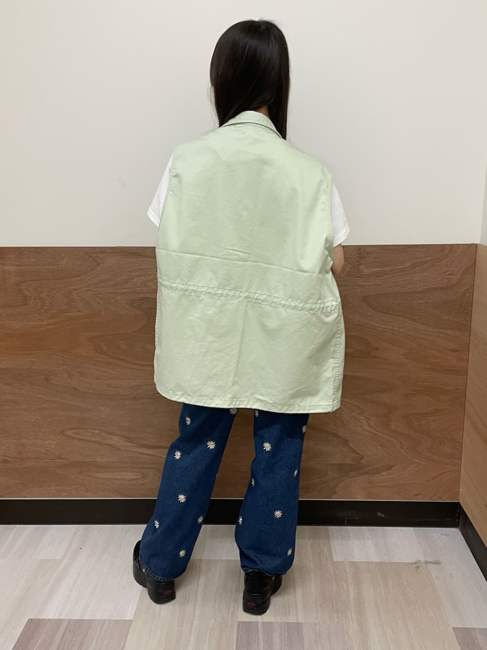 ブルー系のデニムパンツ、ホワイト系のTシャツ/カットソー、グリーン系のベストを着用したレディースの春コーディネートの2枚目の写真