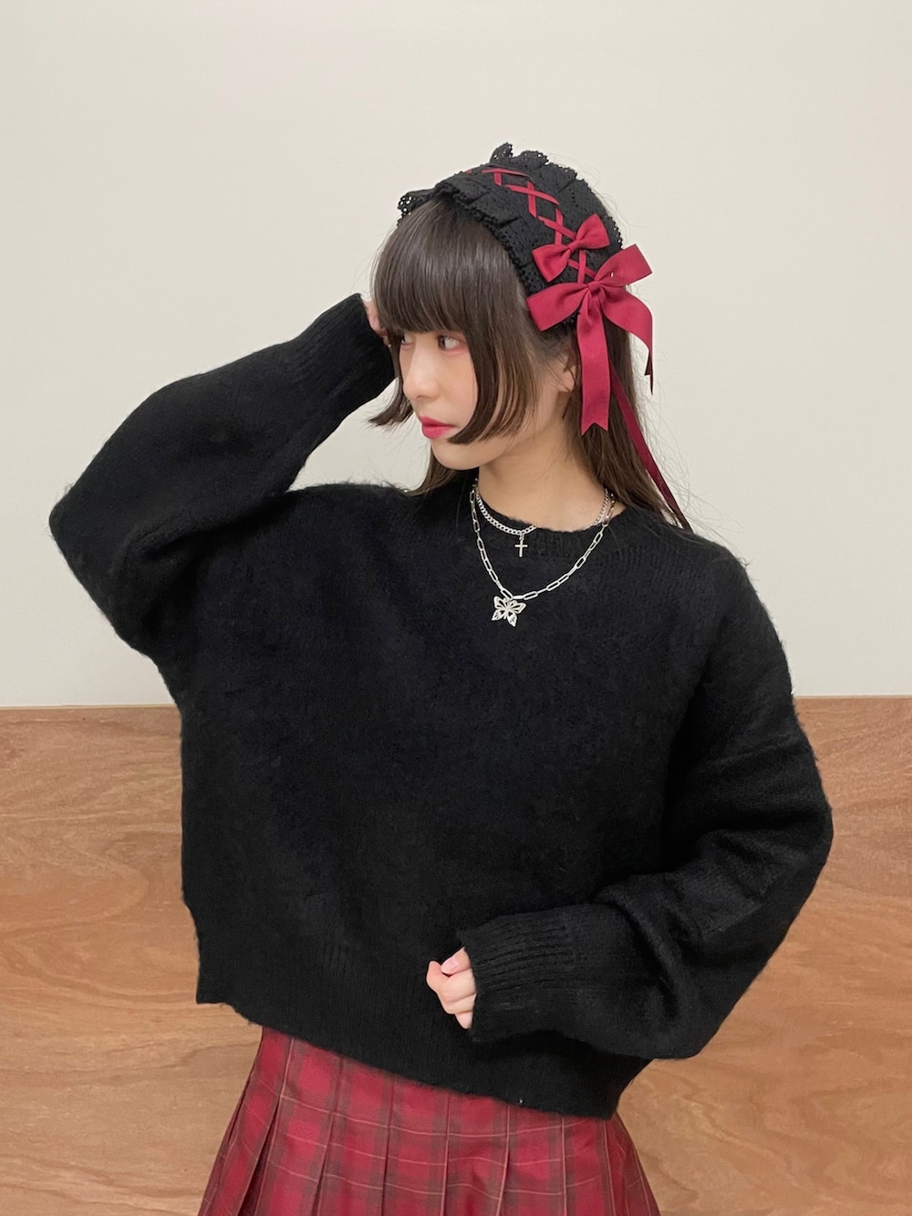 ブラック系のブーツ、レッド系のスカート、ブラック系のニット/セーターを着用したレディースの秋コーディネートの2枚目の写真